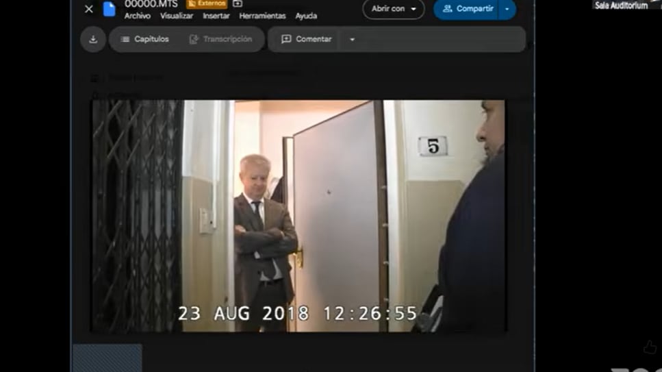 Una de las puertas blindadas y el abogado Beraldi, que estaba en el departamento al momento del allanamiento