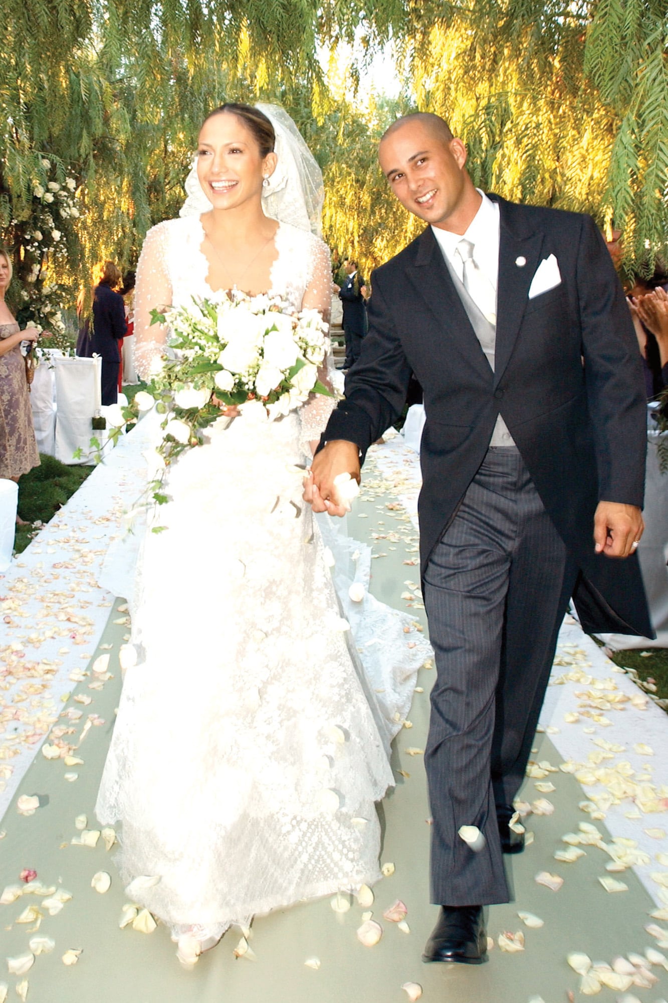 En 2001, Jennifer López se casó con el bailarín Chris Judd y lució un romántico diseño con profundo escote, falda acampanada y mangas transparentes de tul bordado