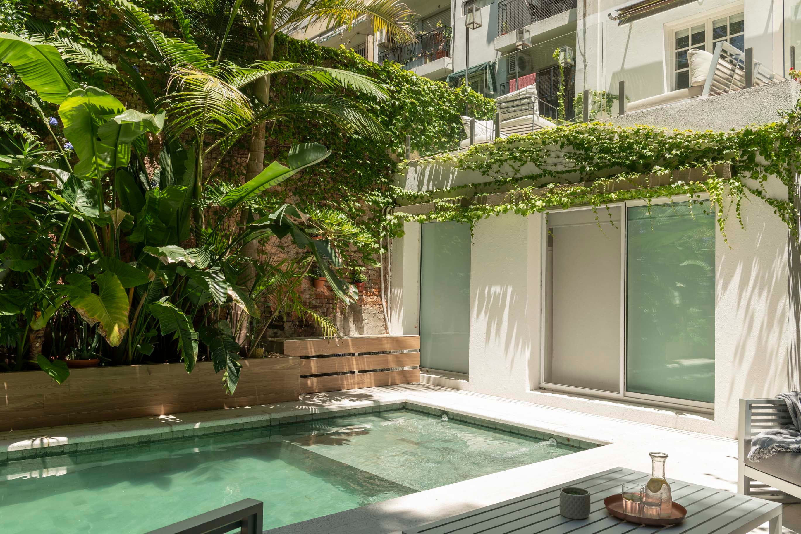 La pileta llega prácticamente hasta los ventanales, donde tiene su menor profundidad. Revestida en Piedra Bali, tiene solarium con piso atérmico.