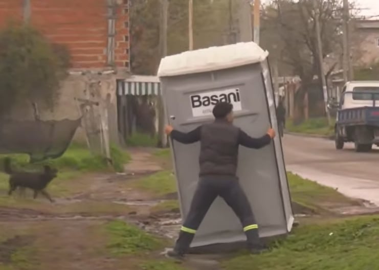 Uno de los empleados de la empresa de baños químicos acomoda las unidades de forma manual