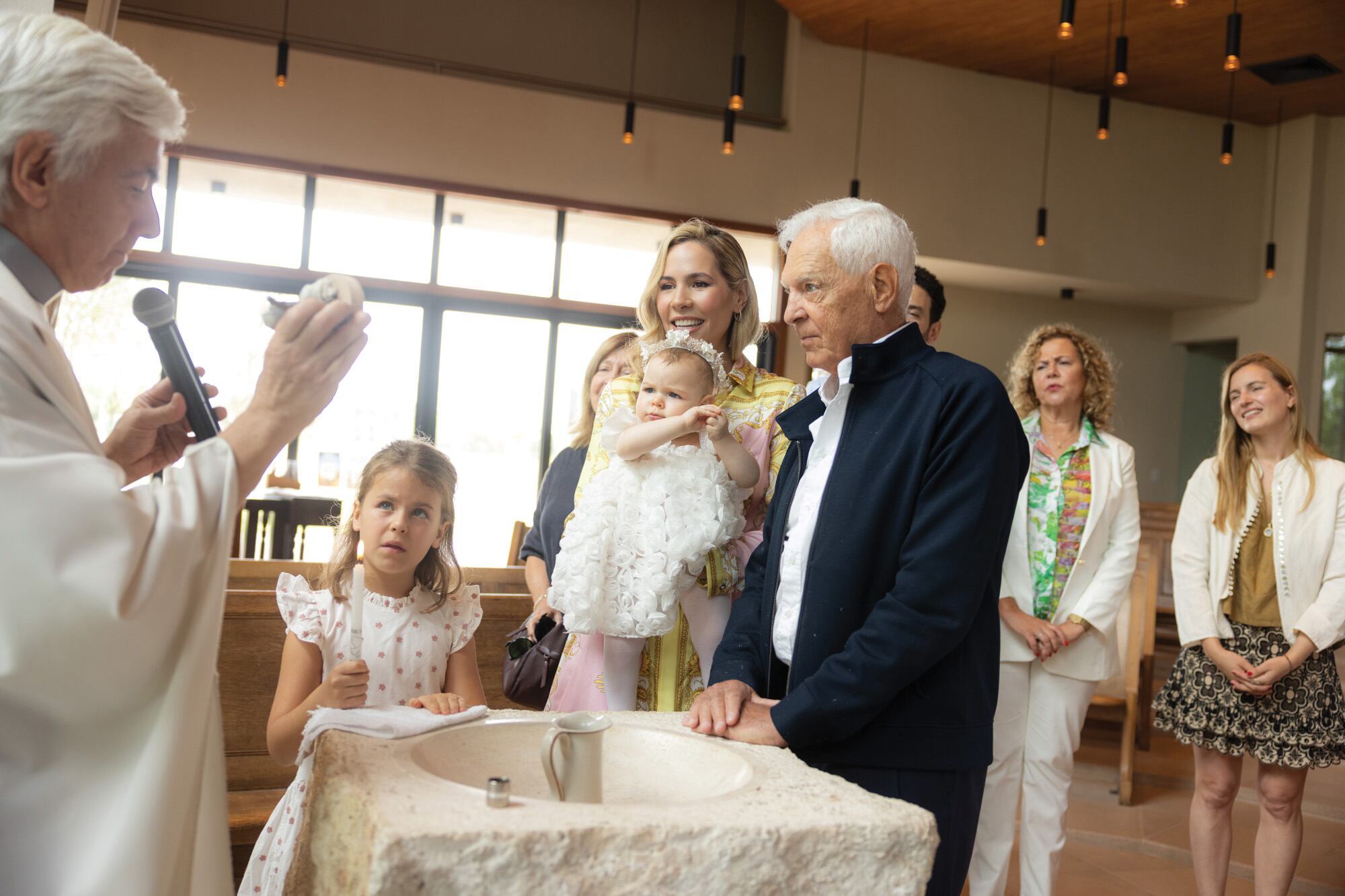 La pareja escucha atentamente la palabra del párroco. Junto a ellos, Mar, la bisnieta de Eduardo, que se lució en su rol de madrina