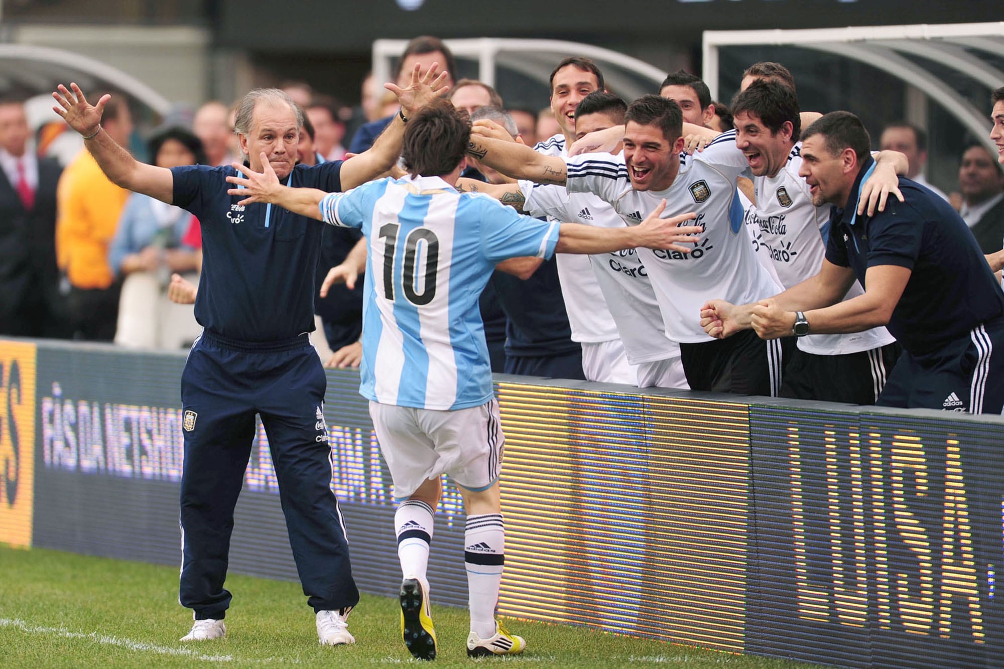 Lionel Messi corre a festejar con el banco de suplentes y el DT Alejandro Sabella su tercer gol frente a Brasil