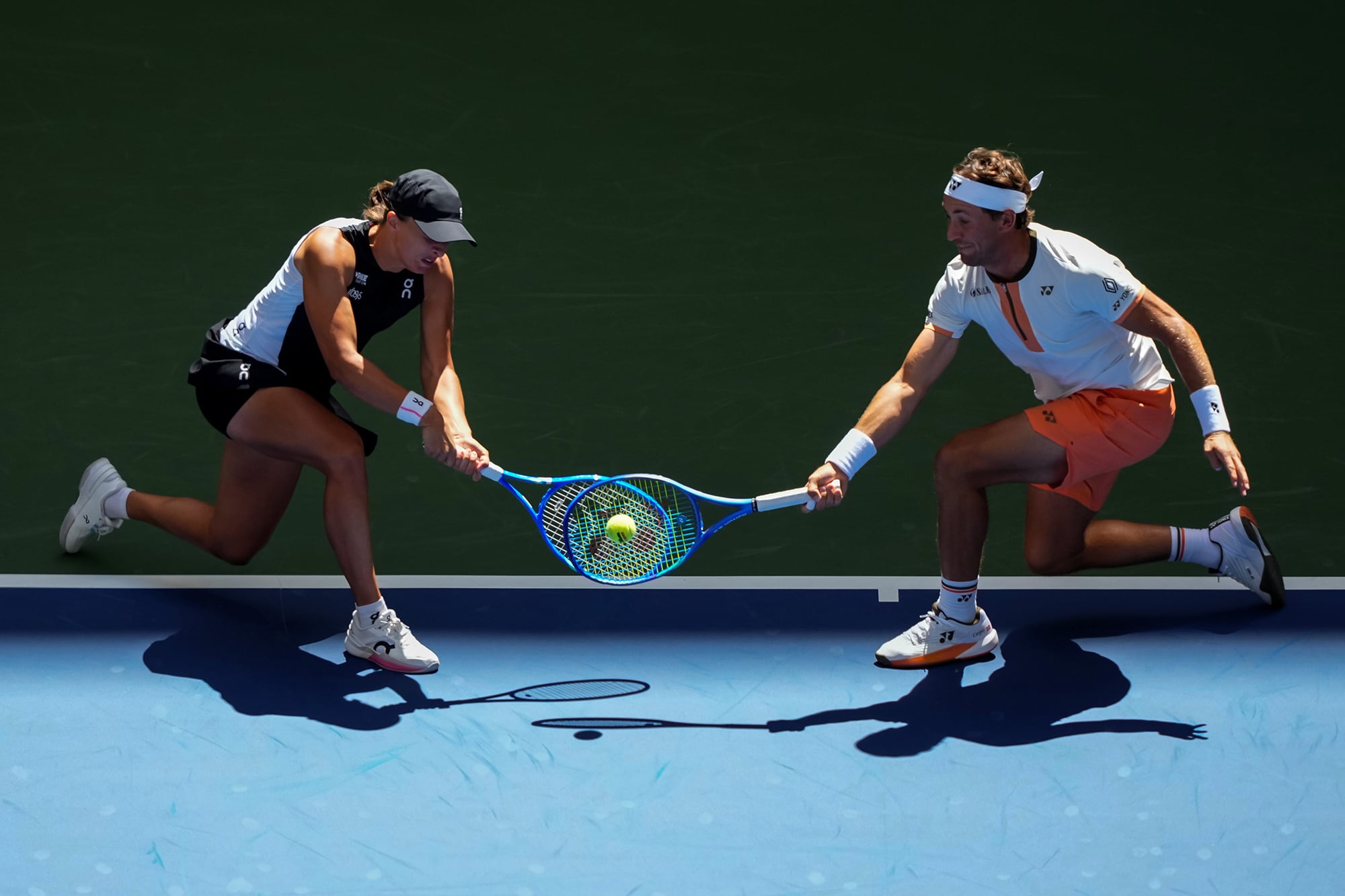 Iga Świątek y Casper Ruud devuelven un tiro simultáneamente durante su partido de dobles mixtos de primera ronda contra Madison Keys y Frances Tiafoe en el Open de Estados Unidos 2025 en Nueva York