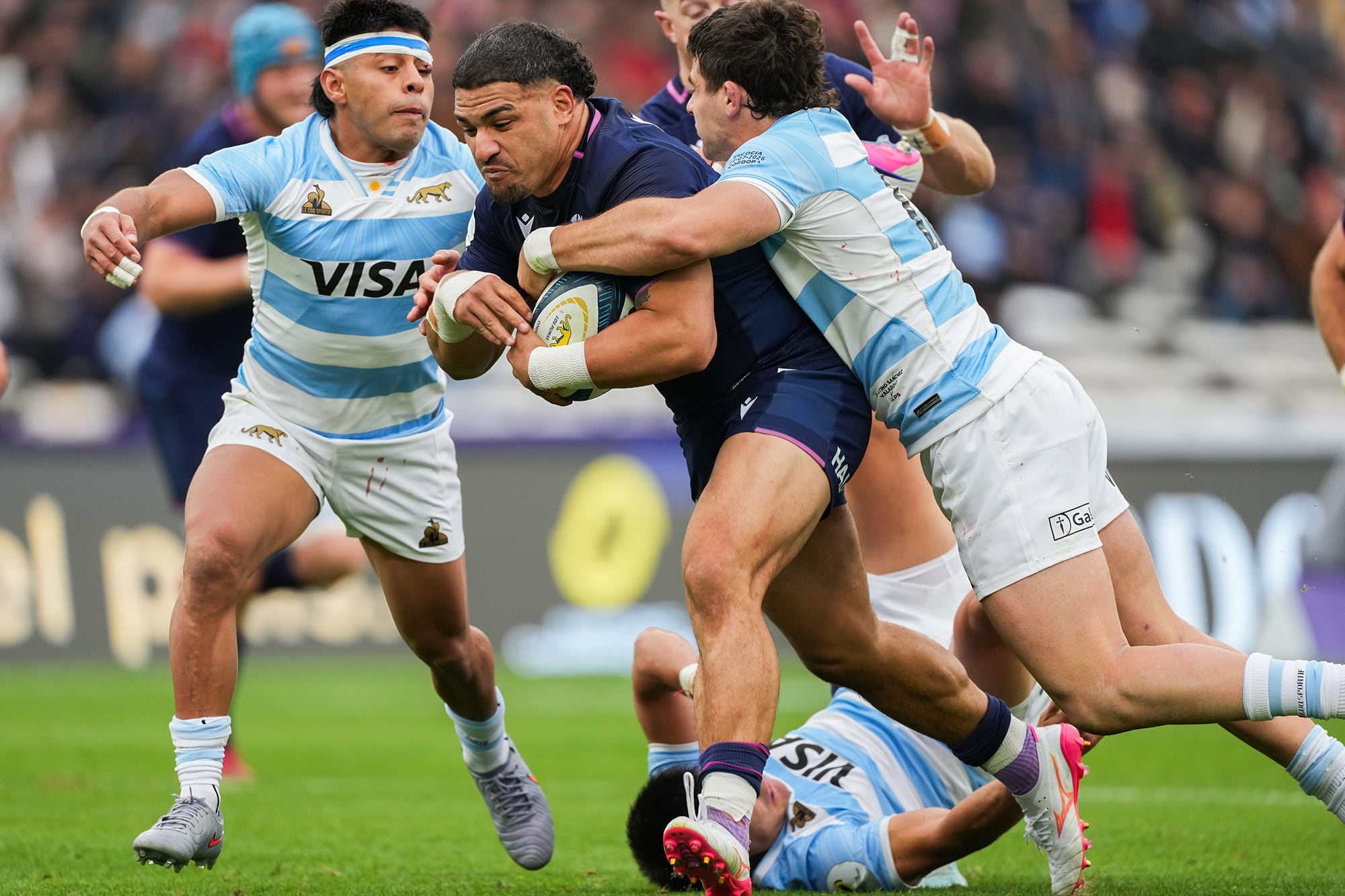El capitán escocés Sione Tuipulotu avanza entre Gonzalo García y el debutante Faustino Sánchez Valarolo; Escocia encontró agujeros por el centro y por las puntas.
