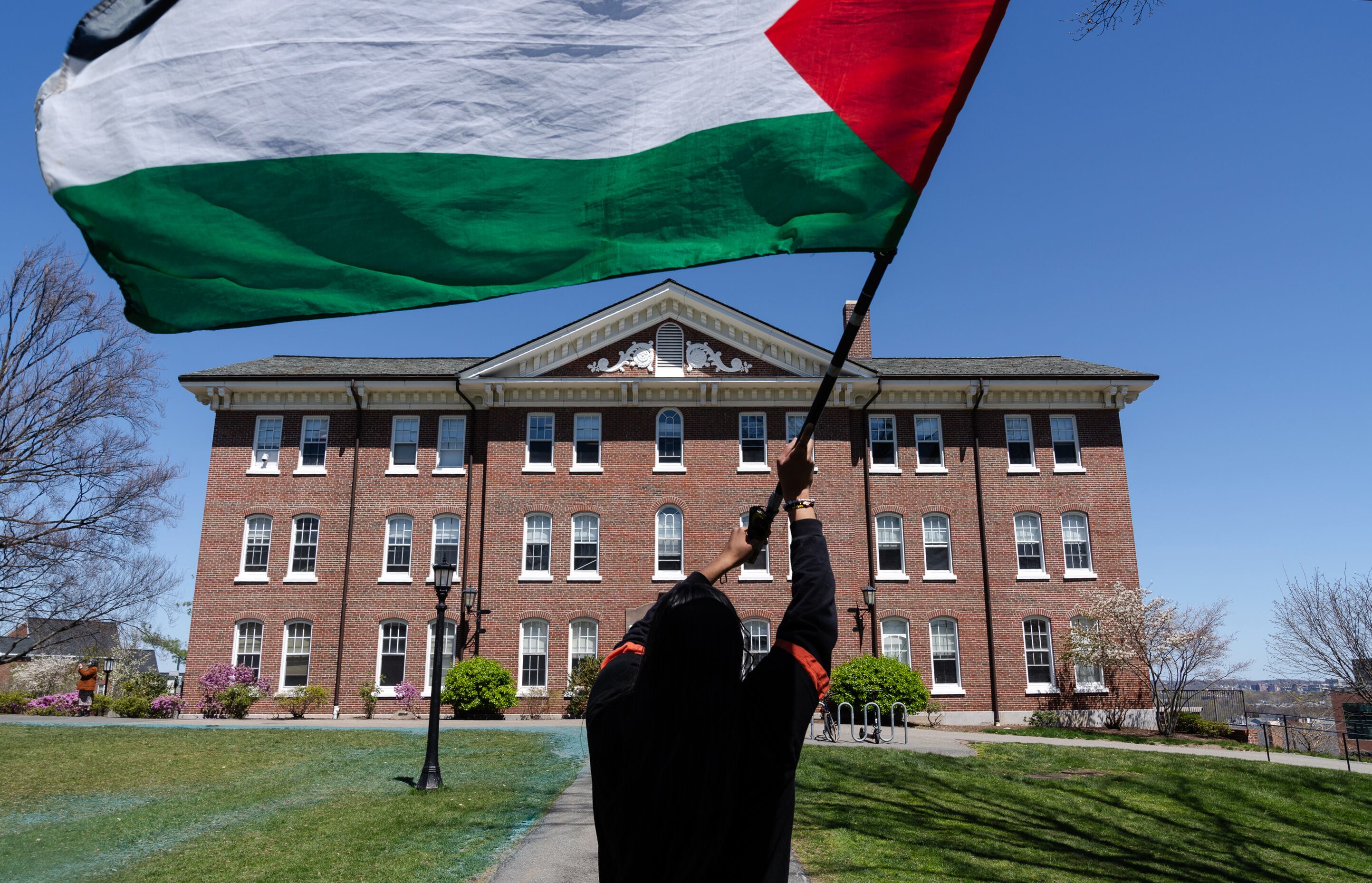 Un manifestante ondea una bandera palestina en el campus de la Tufts University, en Medford. (Sophie Park/The New York Times)
