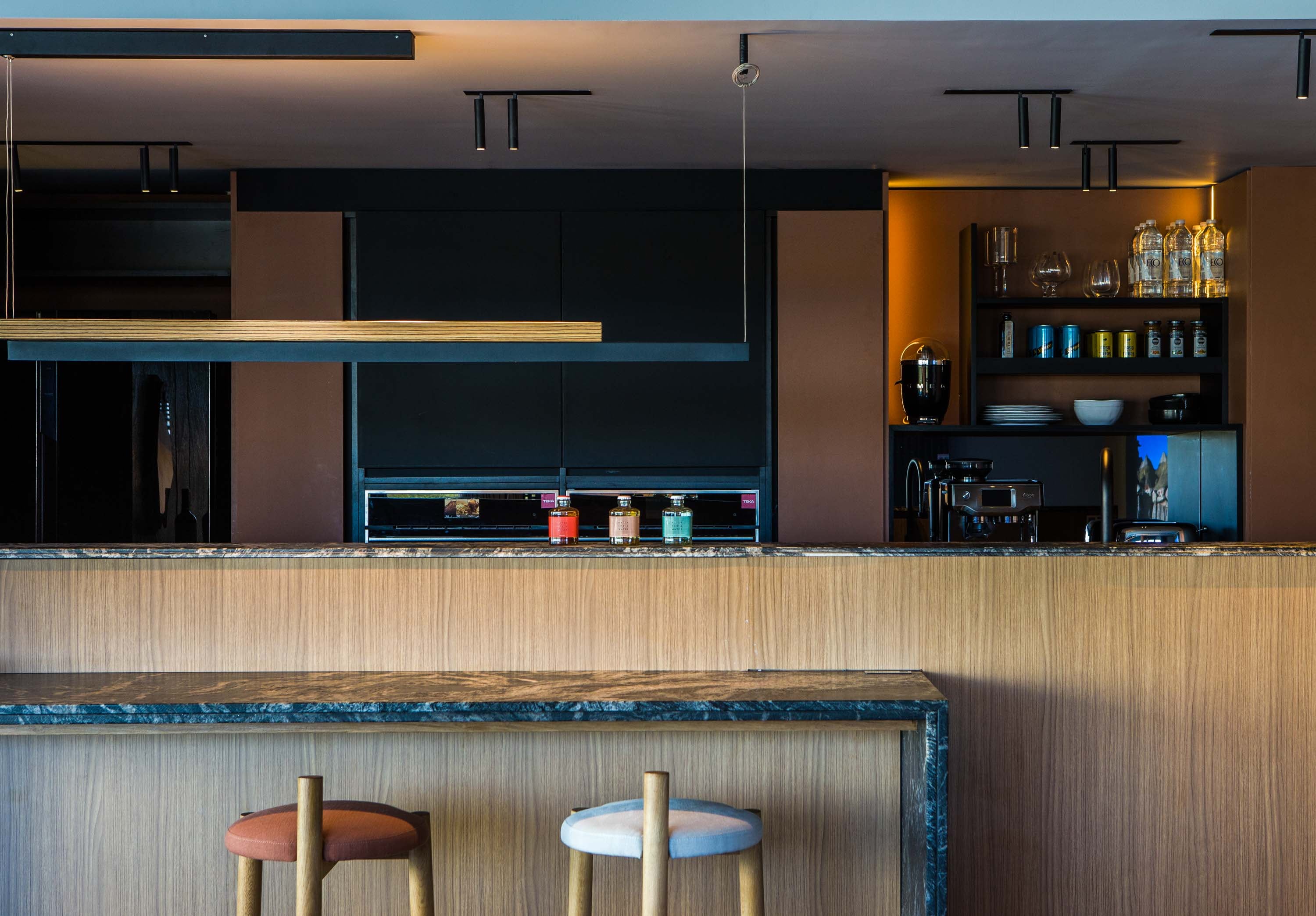 Mesada y plano vertical en granito nacional 'Amadeus' leather (De Stefano) trabajado por Giannetta Mármoles. Los muebles fueron ejecutados por el estudio Pio Auguri. Hornos de Tekka.