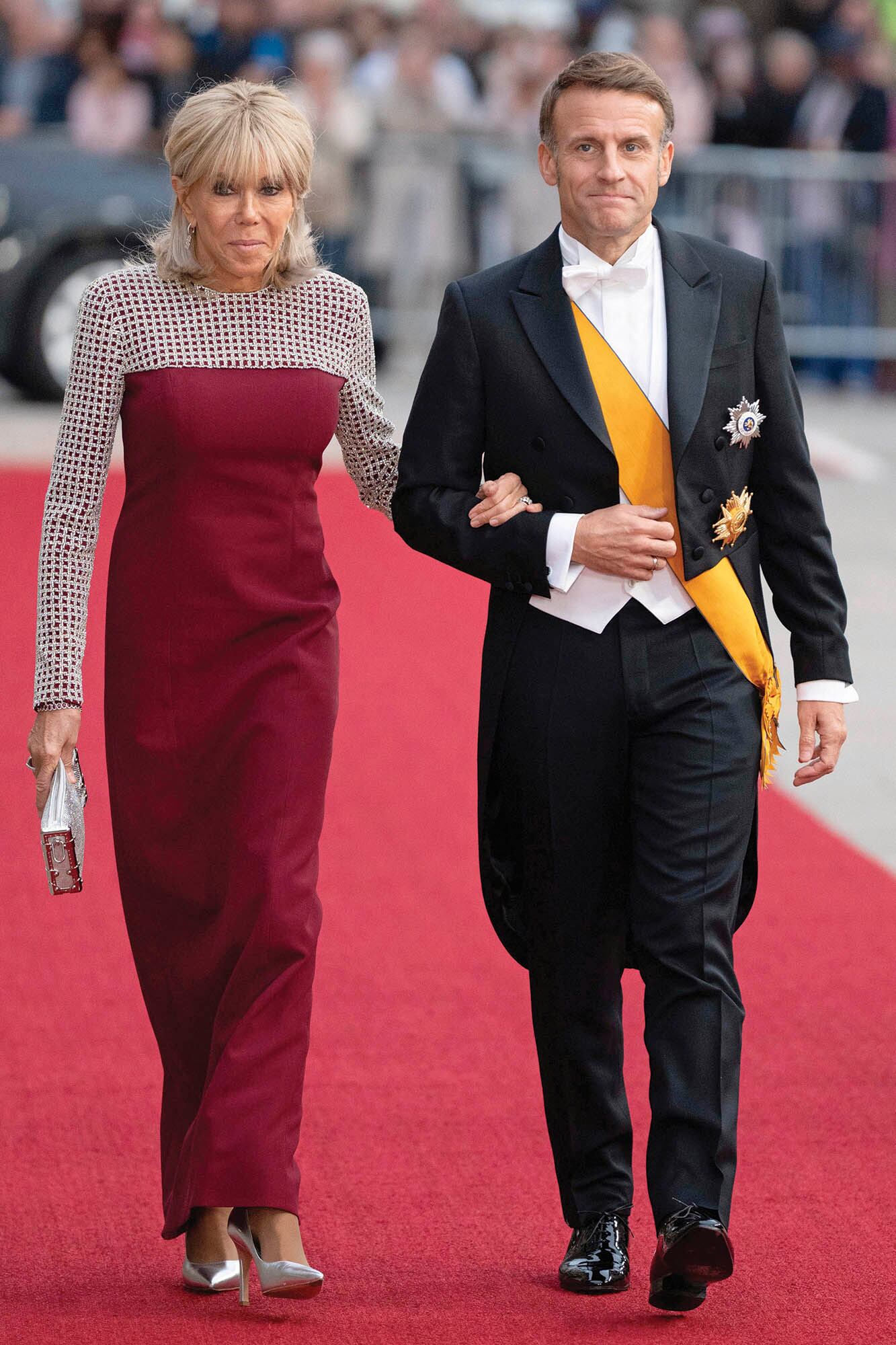 Emmanuel y Brigitte Macron –la primera dama francesa con una creación de líneas depuradas y corte minimalista, decorada con un patrón en malla de red y con pequeñas piedras metalizadas sobre escote y mangas de Louis Vuitton– también participaron de los fastos