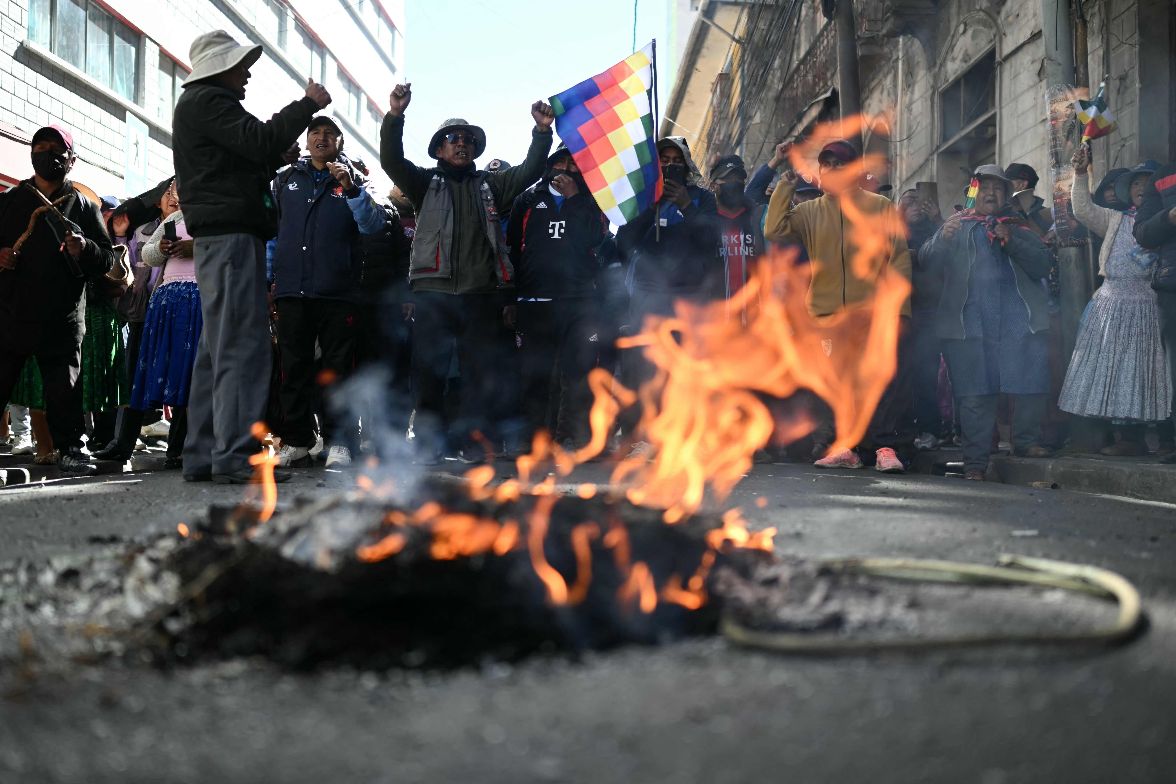Manifestantes corean consignas cerca de un objeto en llamas durante una protesta contra el gobierno del presidente boliviano Rodrigo Paz en La Paz, el 10 de junio de 2026