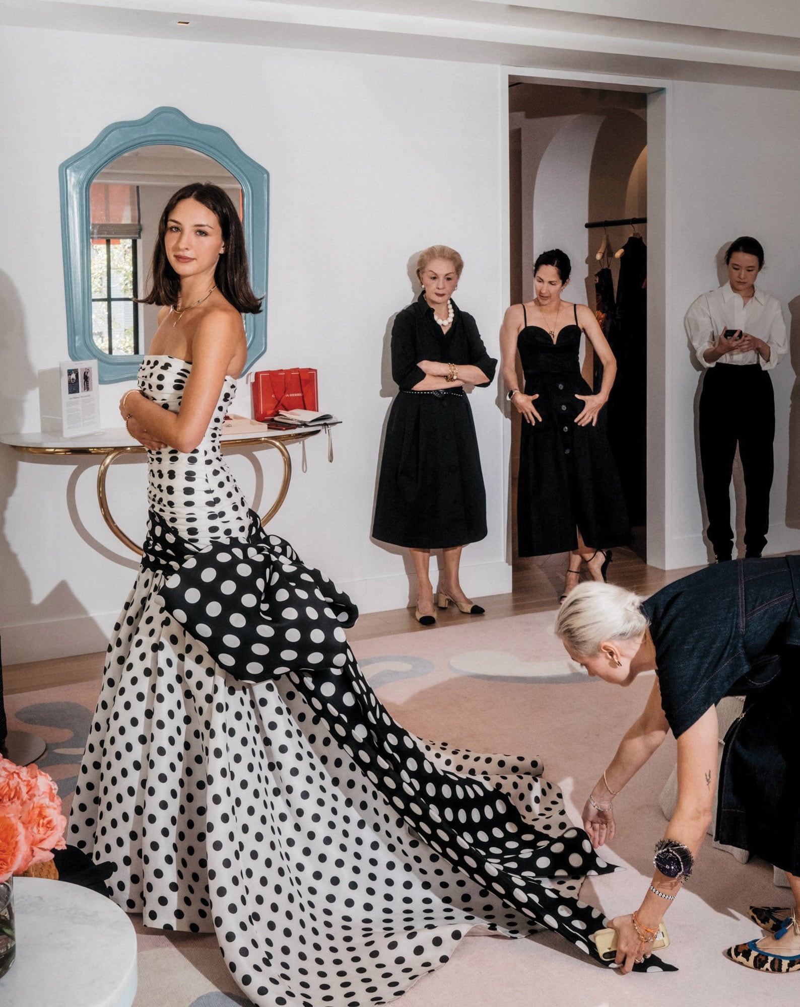 Carolina espera que una modista haga los últimos ajustes al vestido, bajo la mirada de dos expertas: su abuela, Carolina Herrera, y su madre, Patricia