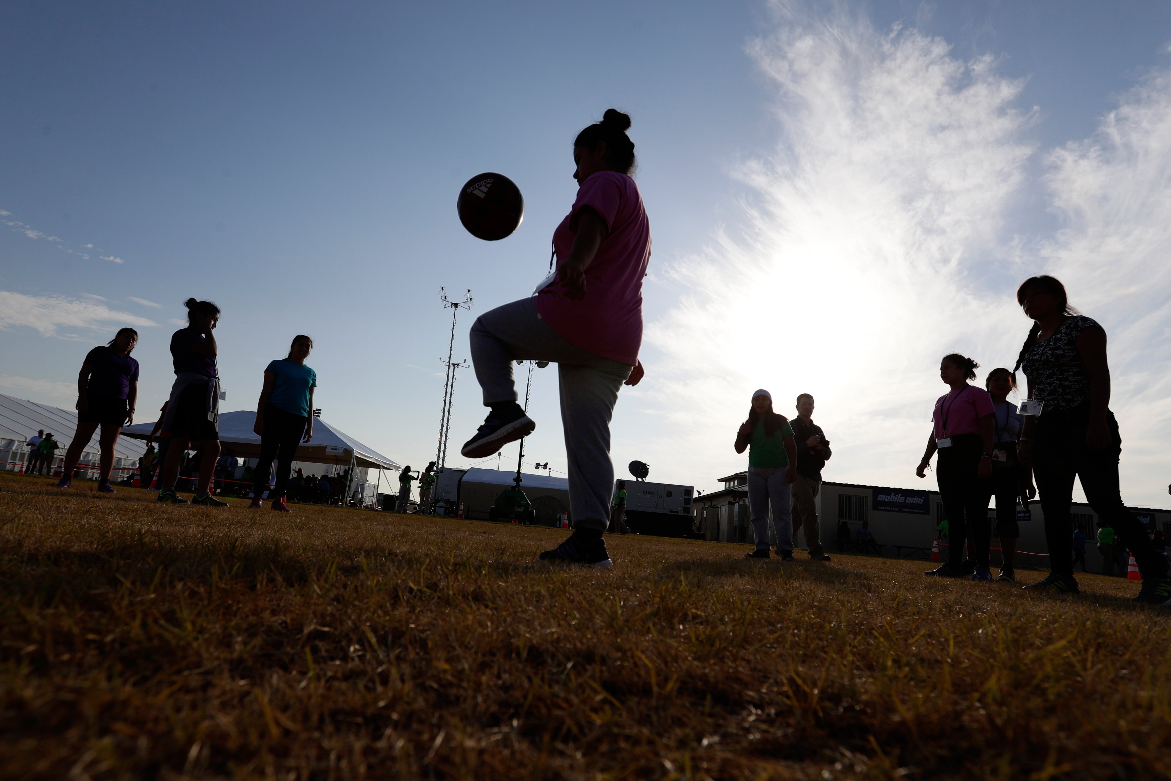 ARCHIVO - Personas juegan fútbol en un centro de detención del gobierno de EE.UU. para niños migrantes, en Carrizo Springs, Texas, el 9 de julio de 2019 (AP Foto/Eric Gay/Archivo)