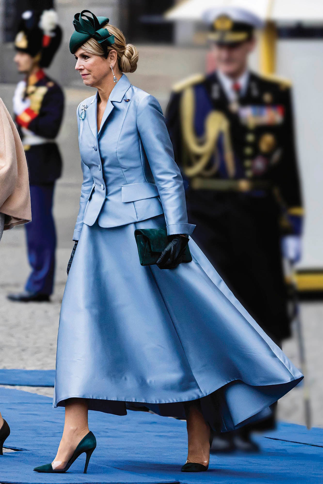 La monarca de Países Bajos con un traje celeste de Natan -una de sus marcas favoritas- con blazer entallado y falda plato asimétrica. Lo complementó con pendientes de aguamarina que pertenecieron a la reina Juliana, guantes de cuero, sobre y stilettos con detalle transparente, también, de Natan