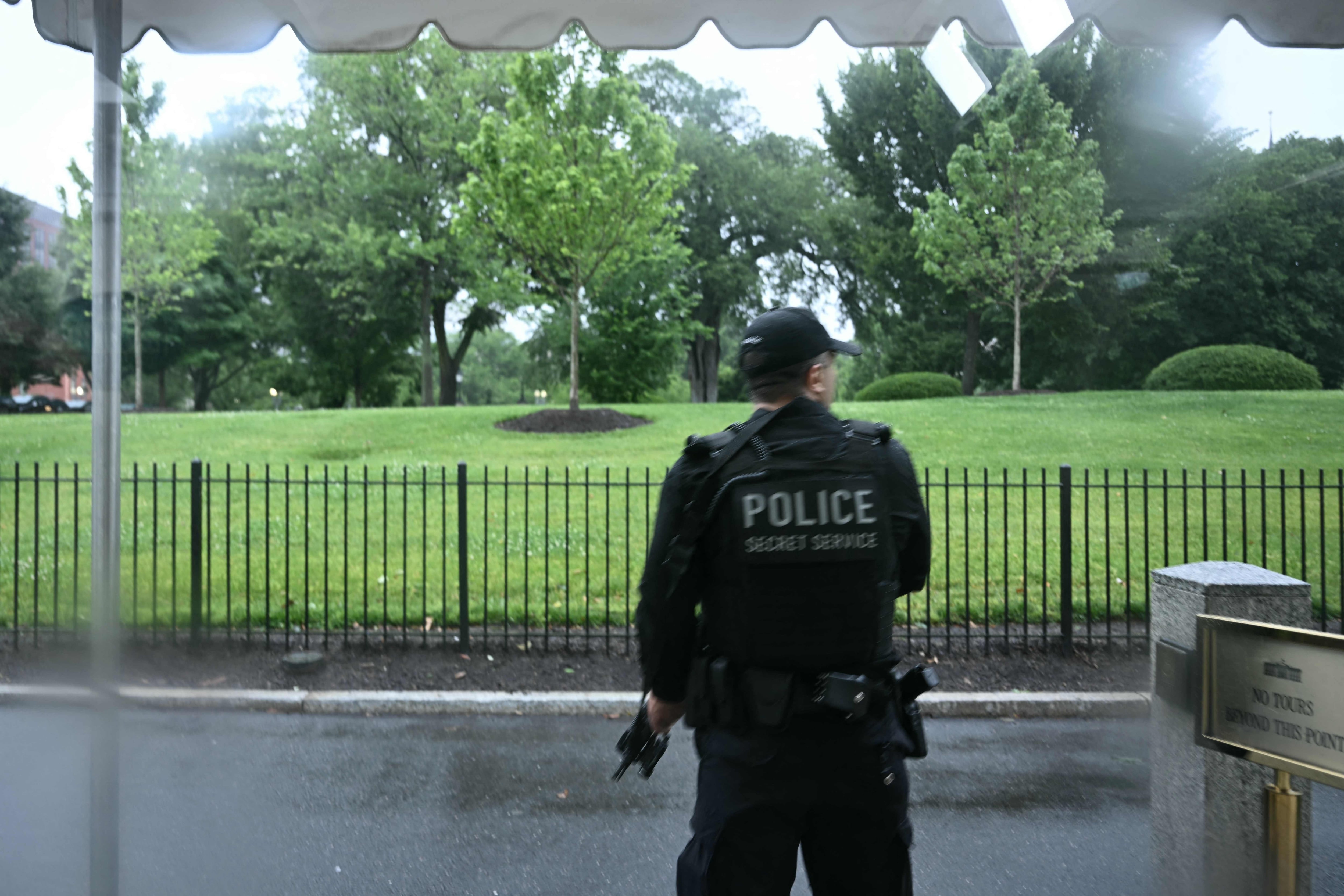Un agente armado del Servicio Secreto reacciona en la Casa Blanca en Washington, DC, después de que aparentemente se escucharan disparos