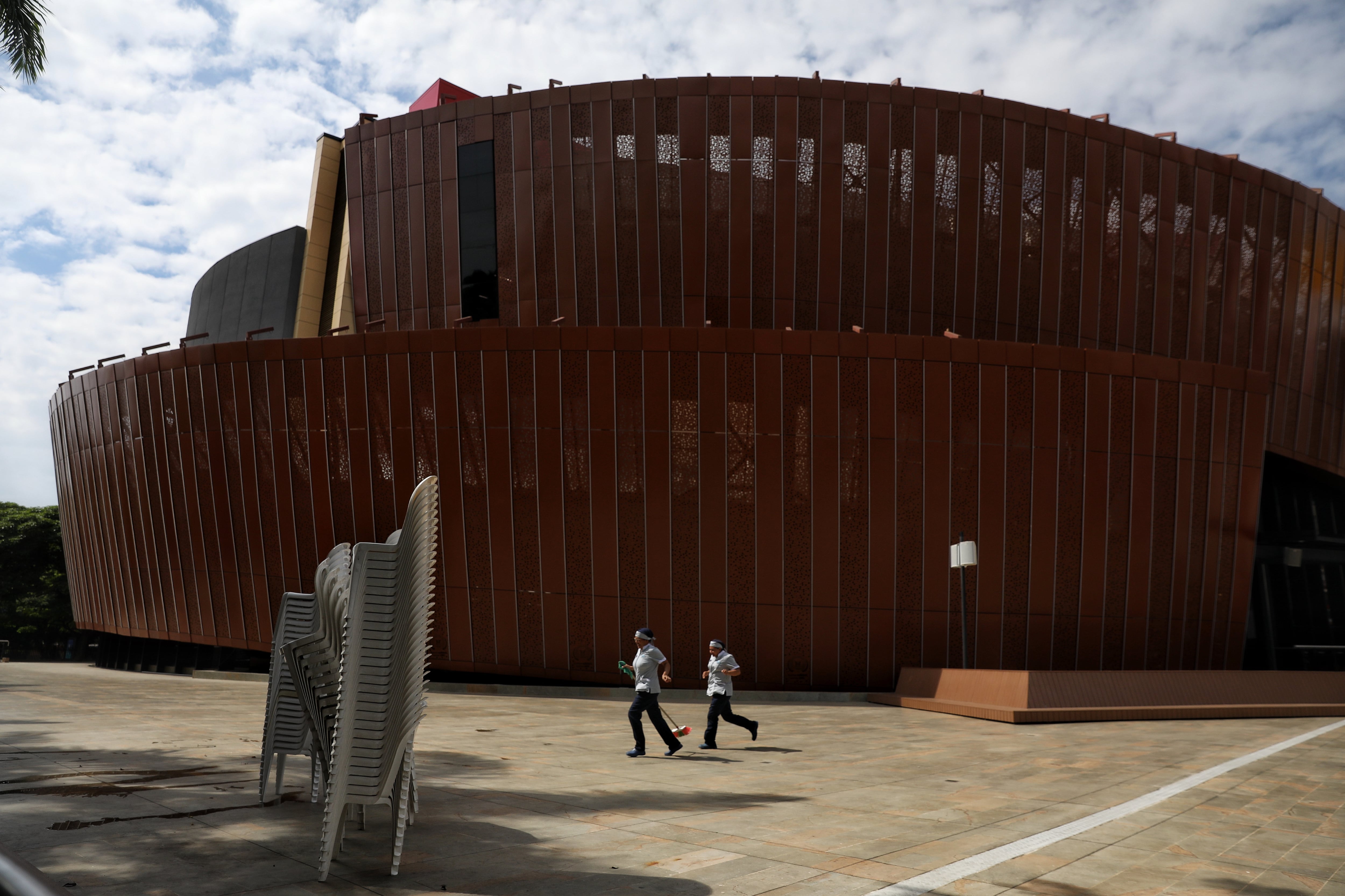 Conserjes caminan afuera del auditorio de la Universidad Santiago de Cali, donde tomará posesión el presidente electo Abelardo de la Espriella, en Cali, Colombia