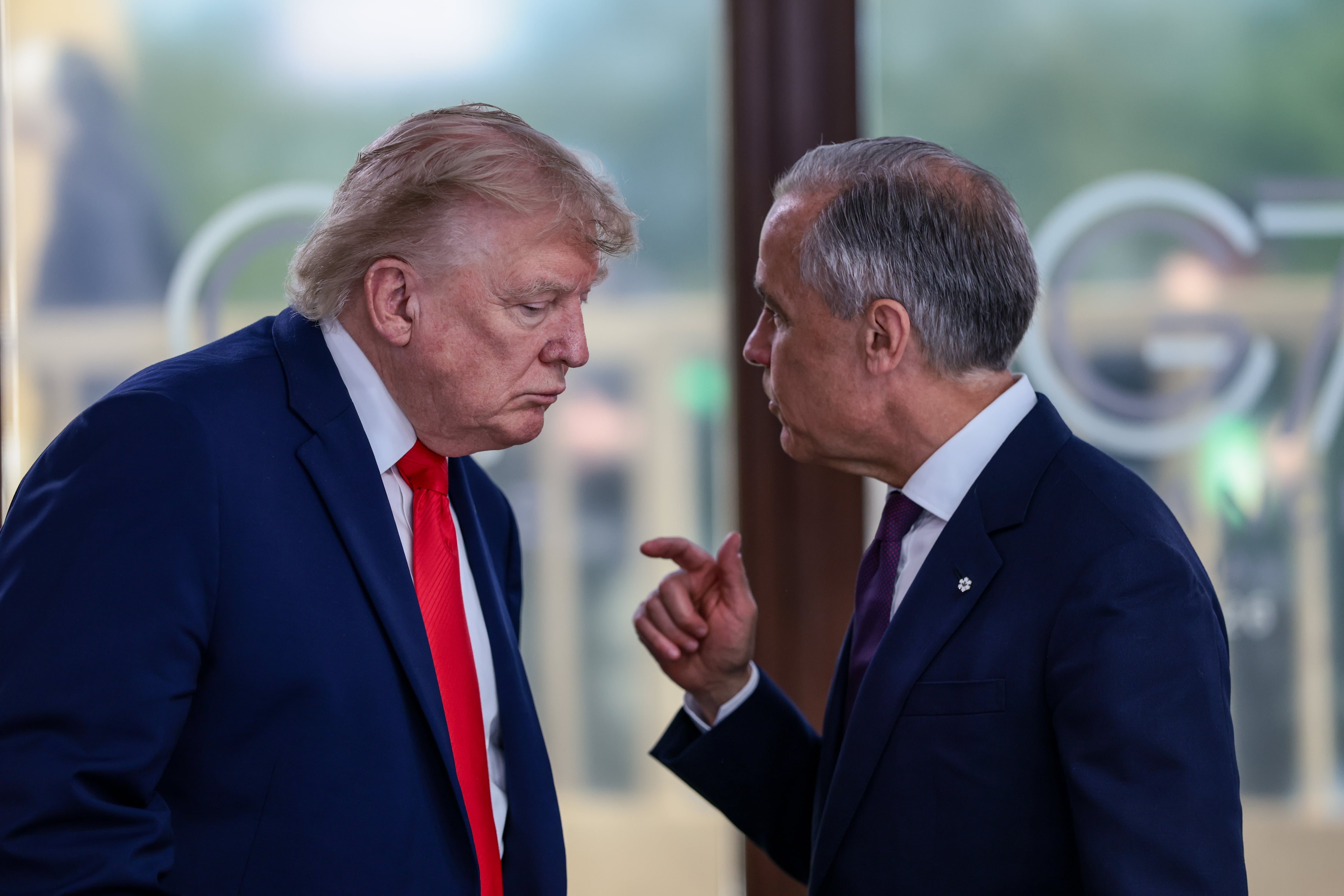 El presidente estadounidense Donald Trump conversa con el primer ministro canadiense Mark Carney, a la derecha, durante un almuerzo de trabajo con líderes del G7 y de Oriente Medio