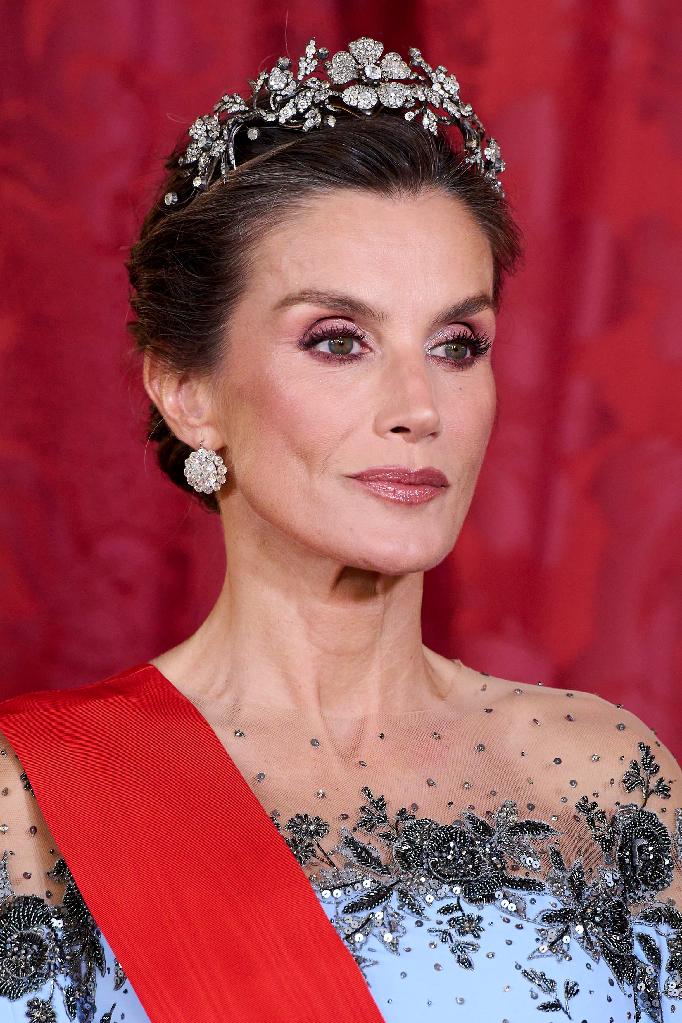 La Reina se coronó con la tiara Floral, una pieza con más de un siglo de historia. Esta joya fue el regalo que el gobierno español hizo a su suegra, la reina Sofía, con motivo de su casamiento con Juan Carlos I, en 1962. Confeccionada en platino y diamantes, su estructura permite que las tres flores principales se desmonten, brindando la posibilidad de lucirlas también como broches independientes o adaptadas como
gargantilla. Le sumó pendientes con brillantes.