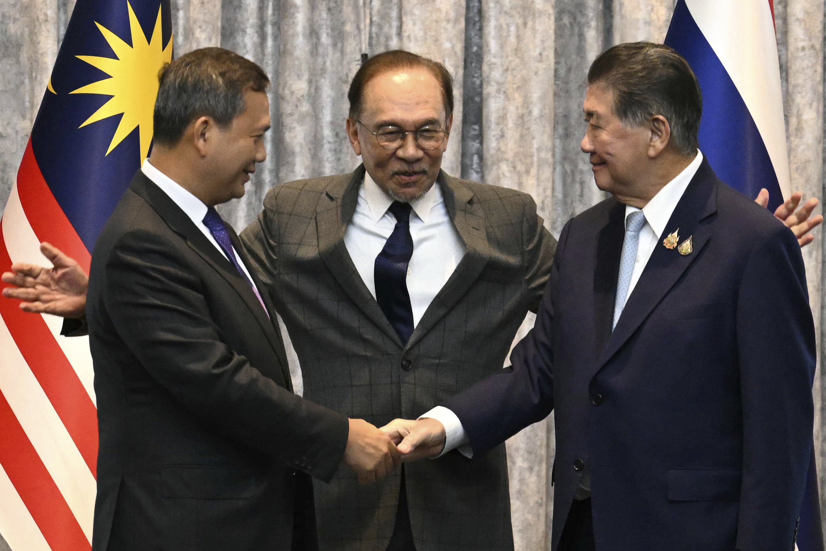 El primer ministro de Camboya, Hun Manet, y el primer ministro interino de Tailandia, Phumtham Wechayachai, se dan la mano mientras el primer ministro de Malasia, Anwar Ibrahim, hace un gesto tras las conversaciones sobre un posible alto el fuego entre Tailandia y Camboya en Putrajaya, Malasia, el lunes 28 de julio de 2025.