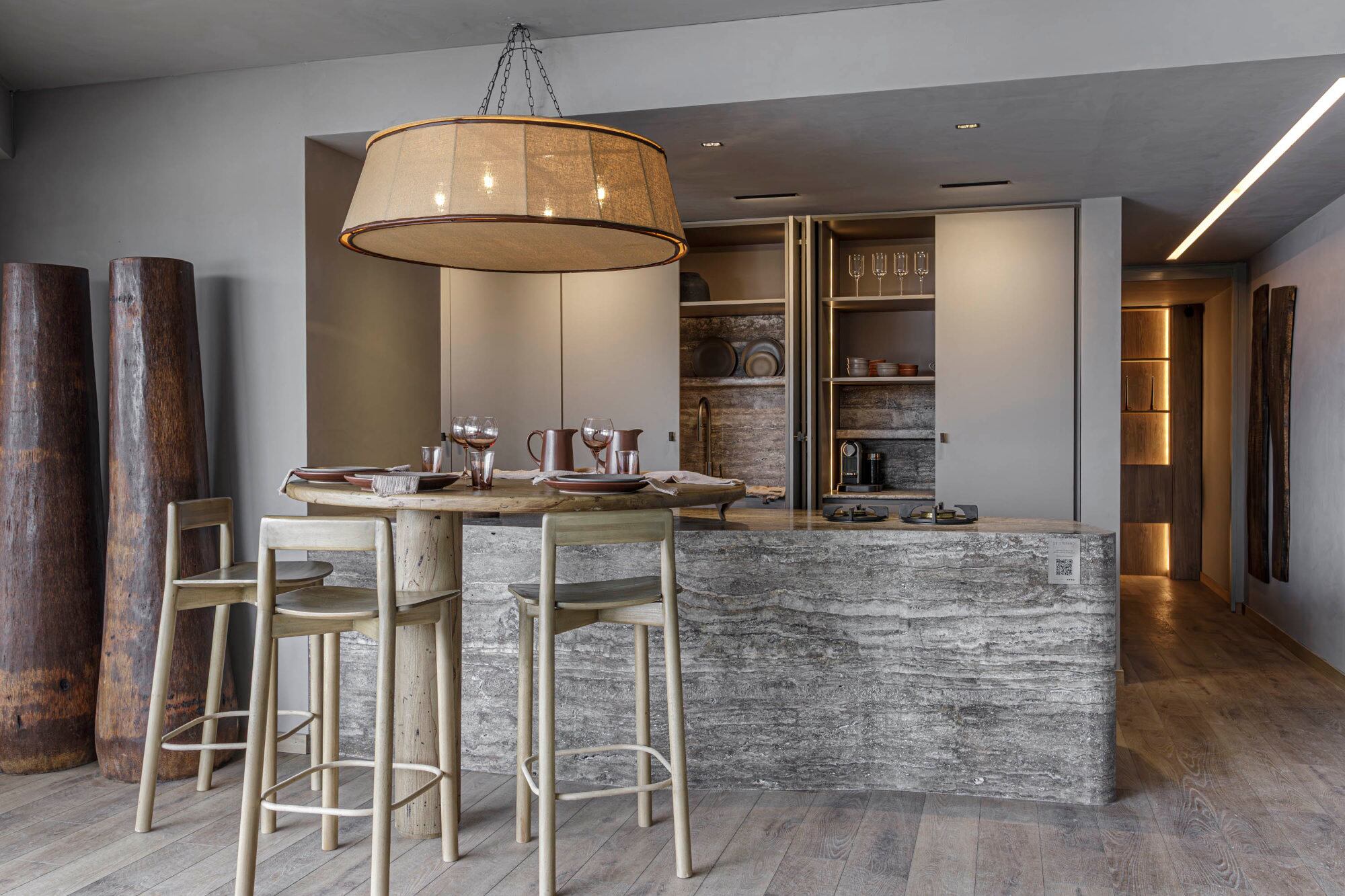 La cocina con una gran mesada que continúa en una mesa redonda de madera
