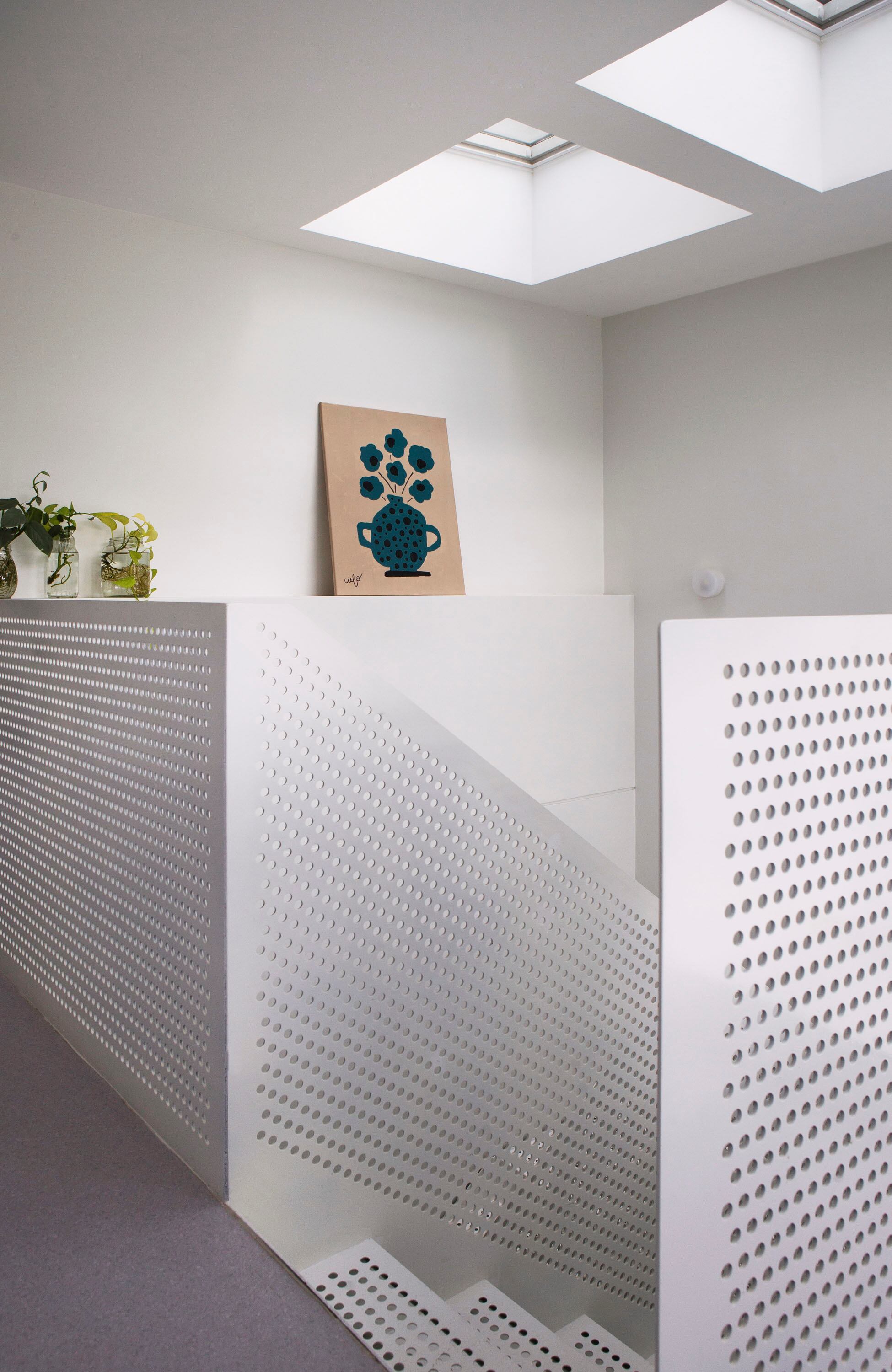 Arriba del hueco de la escalera, dos ventanas de techo Velux con panel solar se abren y cierran solas según el clima.