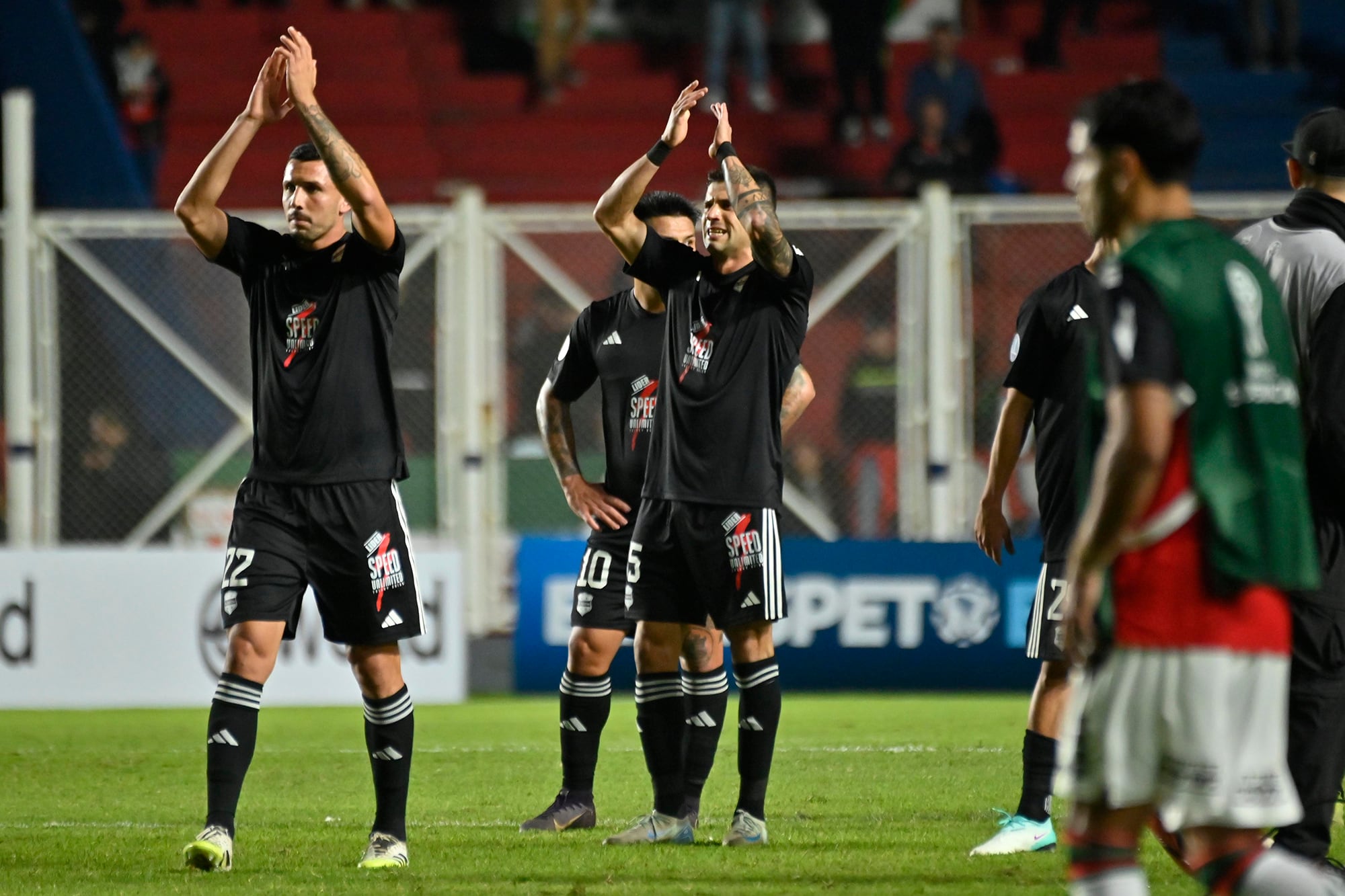 Cristian Paz y Stringa saludan al público en el Pedro Bidegain, el escenario de la primera vez internacional para Riestra, que vivió una fiesta pese al empate sin goles.