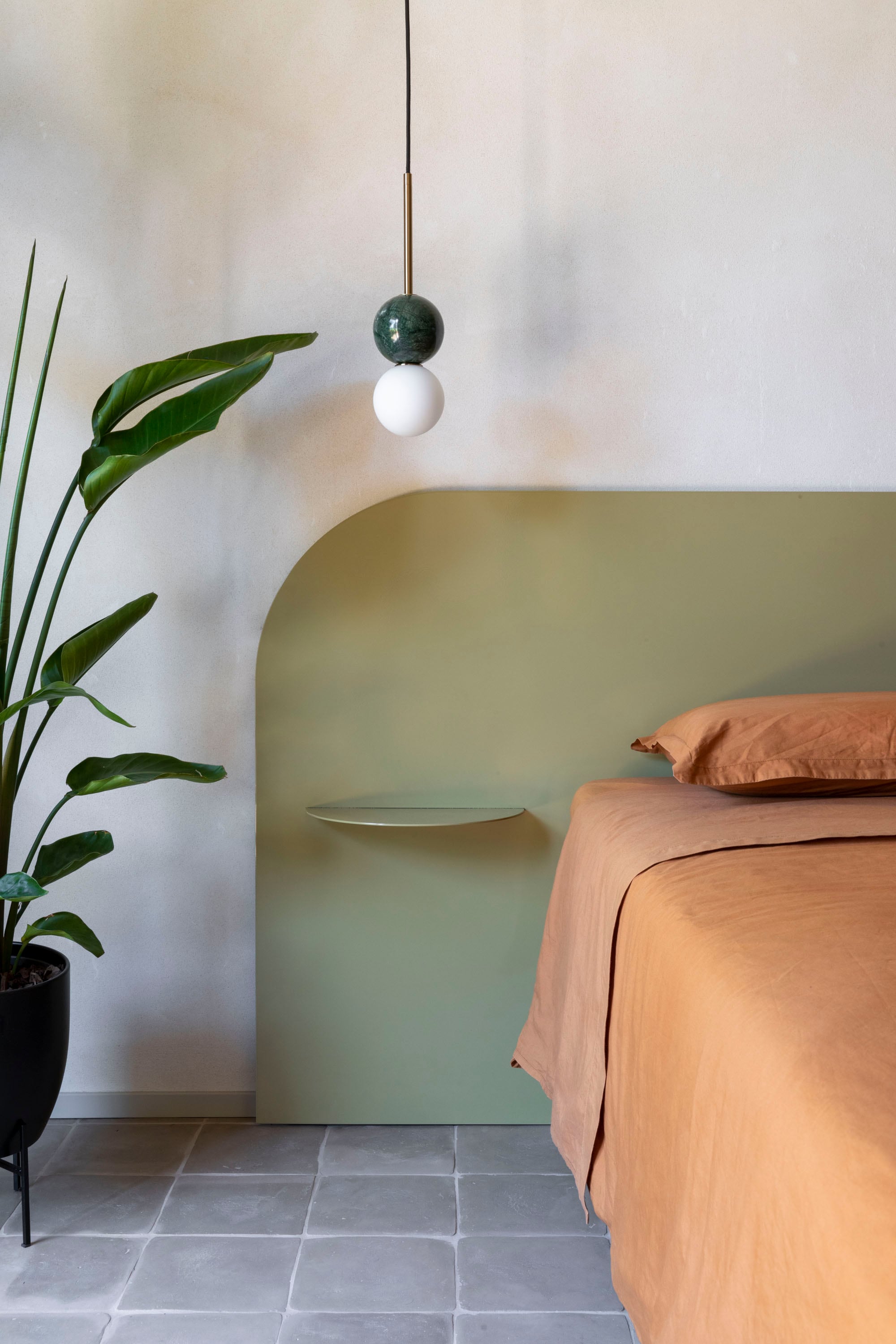 La cama y la cabecera, en hierro pintado, fueron diseñados a medida por STUDIOTAMAT. Lámparas 'Dalt' de metal y mármol (Aromas del campo).