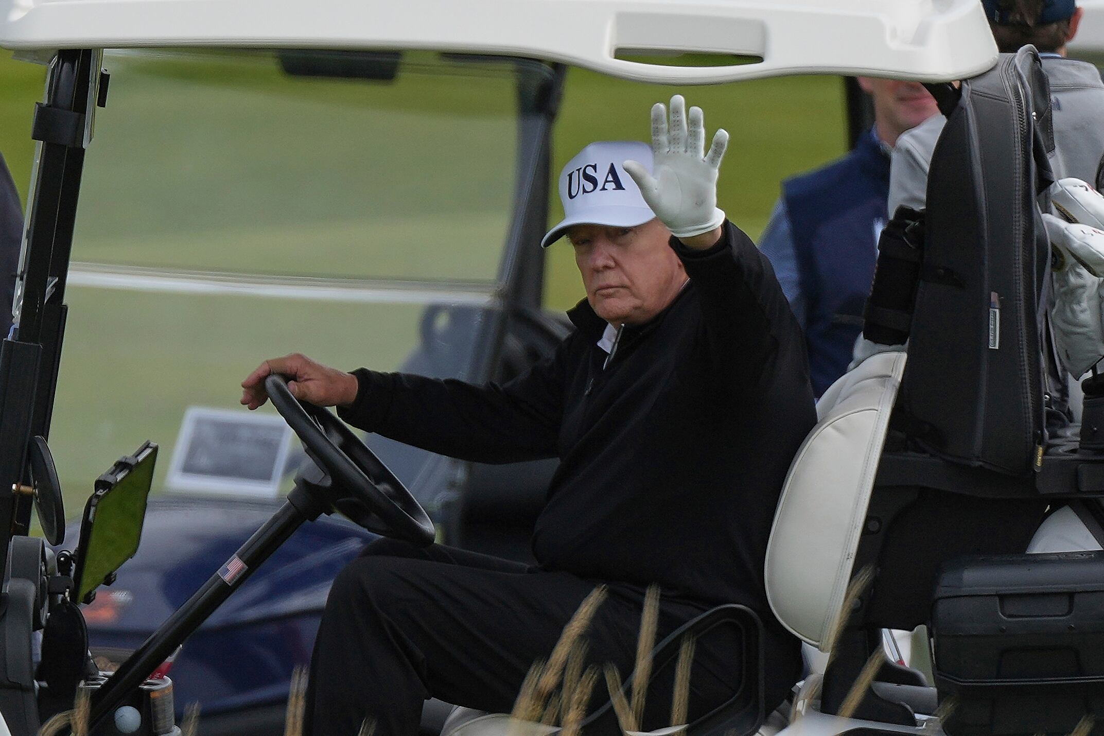 El presidente Donald Trump saluda a los periodistas mientras recorre el campo de golf Trump Turnberry en Turnberry, Escocia, el sábado 26 de julio de 2025.