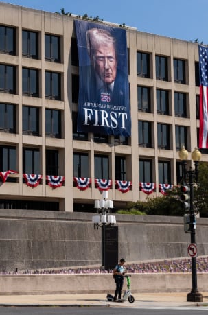 Un enorme cartel con el rostro de Donald Trump y el lema “America Comes First” cubre un edificio federal en Washington, en una exhibición de personalismo que generó críticas incluso entre funcionarios retirados