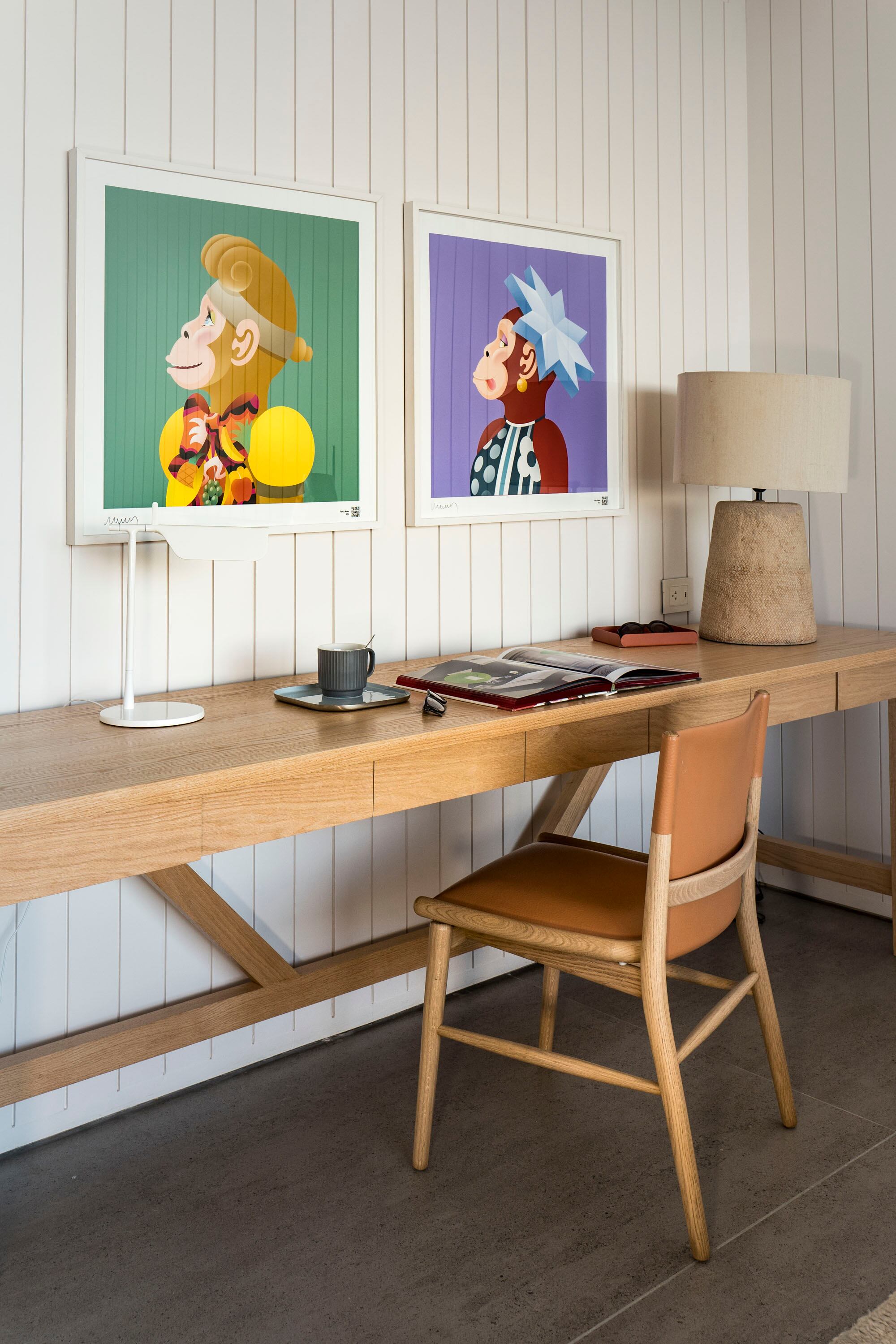 Dos “Fancy Monas” del artista argentino Edgardo Giménez sobre el escritorio hecho a medida en roble, con lámparas con base de cemento y otra modelo ‘Tab’ (Flos) con cabezal ajustable.