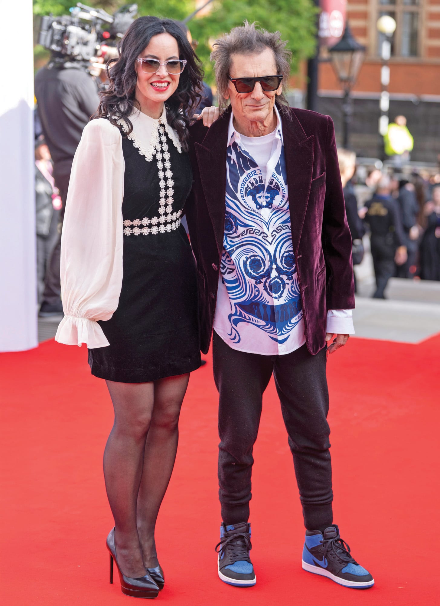 Ronnie Wood posa
con un saco de
terciopelo de Saint
Laurent y camisa
ilustrada mientras
que su mujer,
Sally Humphreys,
lleva un vestido
corto de terciopelo
negro de SelfPortrait