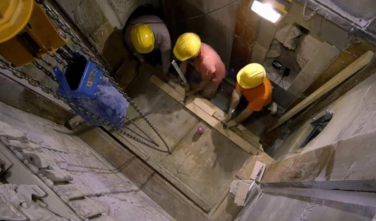 Los arqueólogos de la Universidad de Atenas remueven la más que milenaria lápida de mármol que cubre la tumba de Jesús en el Santo Sepulcro (captura de TV)
