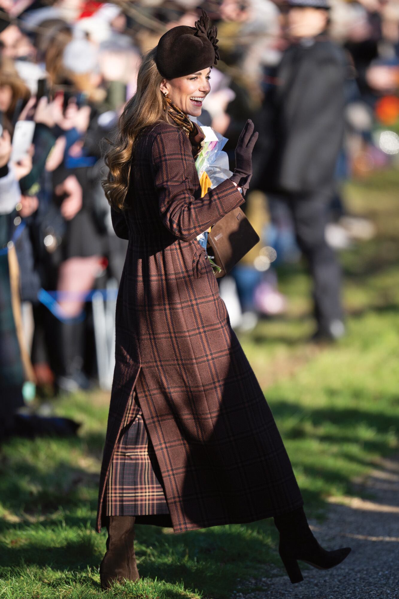 Kate lució el abrigo de tweed, firmado por Blazé Milano, que ya había llevado cuando visitó el hospital Royal Marsden de Londres, en enero pasado. Lo completó con un pañuelo de seda, un tocado de Juliette Millinery, botas de gamuza Gianvito Rossi, aros Cartier y guantes de Cornelia James