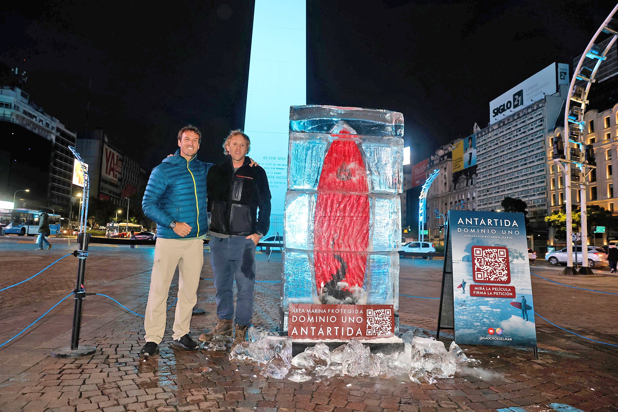 Instalación con bloques de hielo y una tabla de surf en el obelisco para tomar conciencia y juntar firmas para la creación de un área marina protegida en la Antártida.
