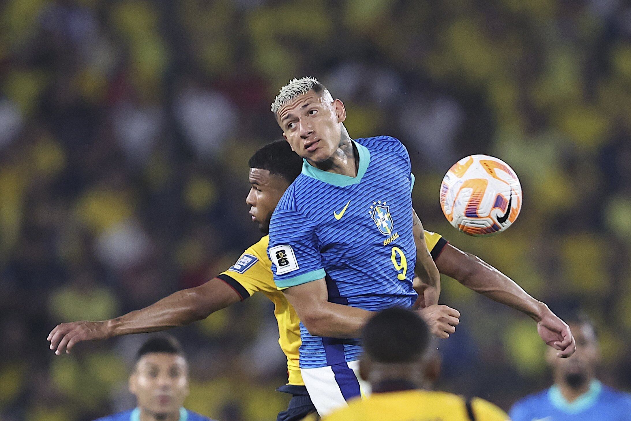 El brasileño Richarlison (9) salta a disputar la pelota con el ecuatoriano Pedro Vite poco antes de ser reemplazado
