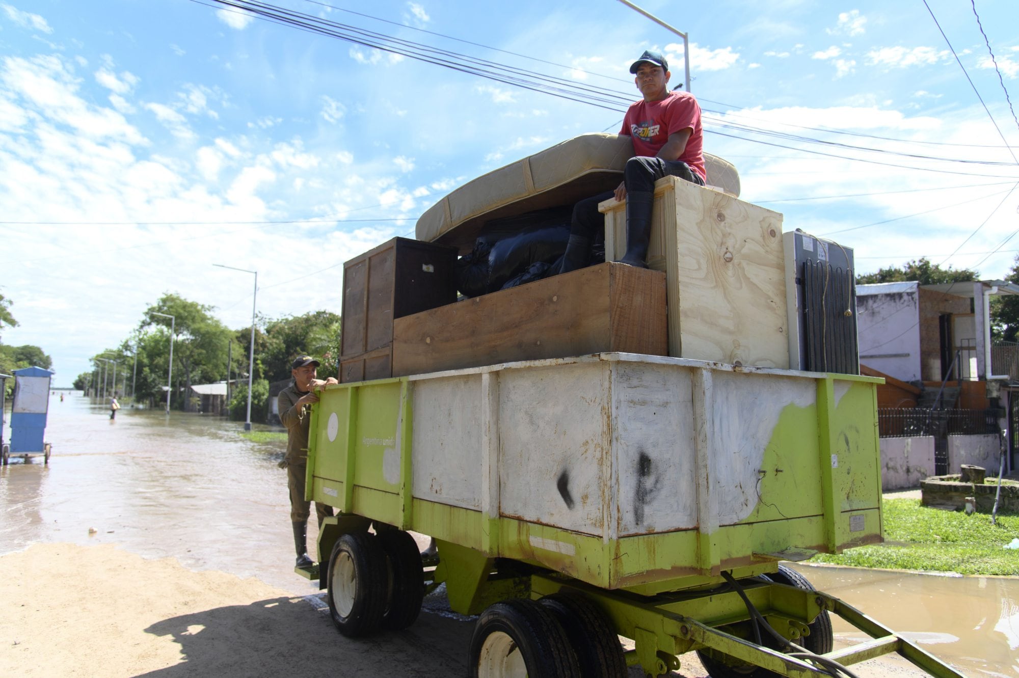 En un acoplado, la familia Ramírez transporta tres colchones, una mesa, cuatro sillas y una heladera cubierta con frazadas