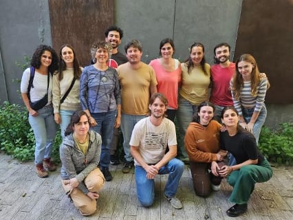 Andrea Gamarnik (tercera desde la izq.) junto a Santiago Oviedo-Rouco (remera beige), Mernoosh Arrar (remera blanca) y el resto del grupo de su laboratorio.