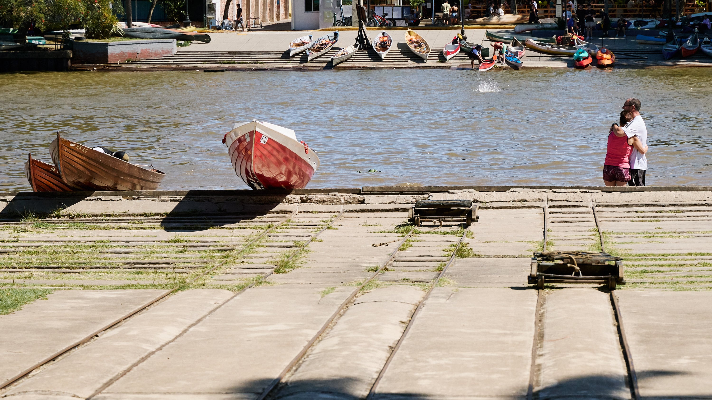 Como aquel casamiento de Osvaldo y Patricia, otra pareja se abraza de espaldas en la rampa del club, entre botes y el río, durante una tarde de actividades sociales