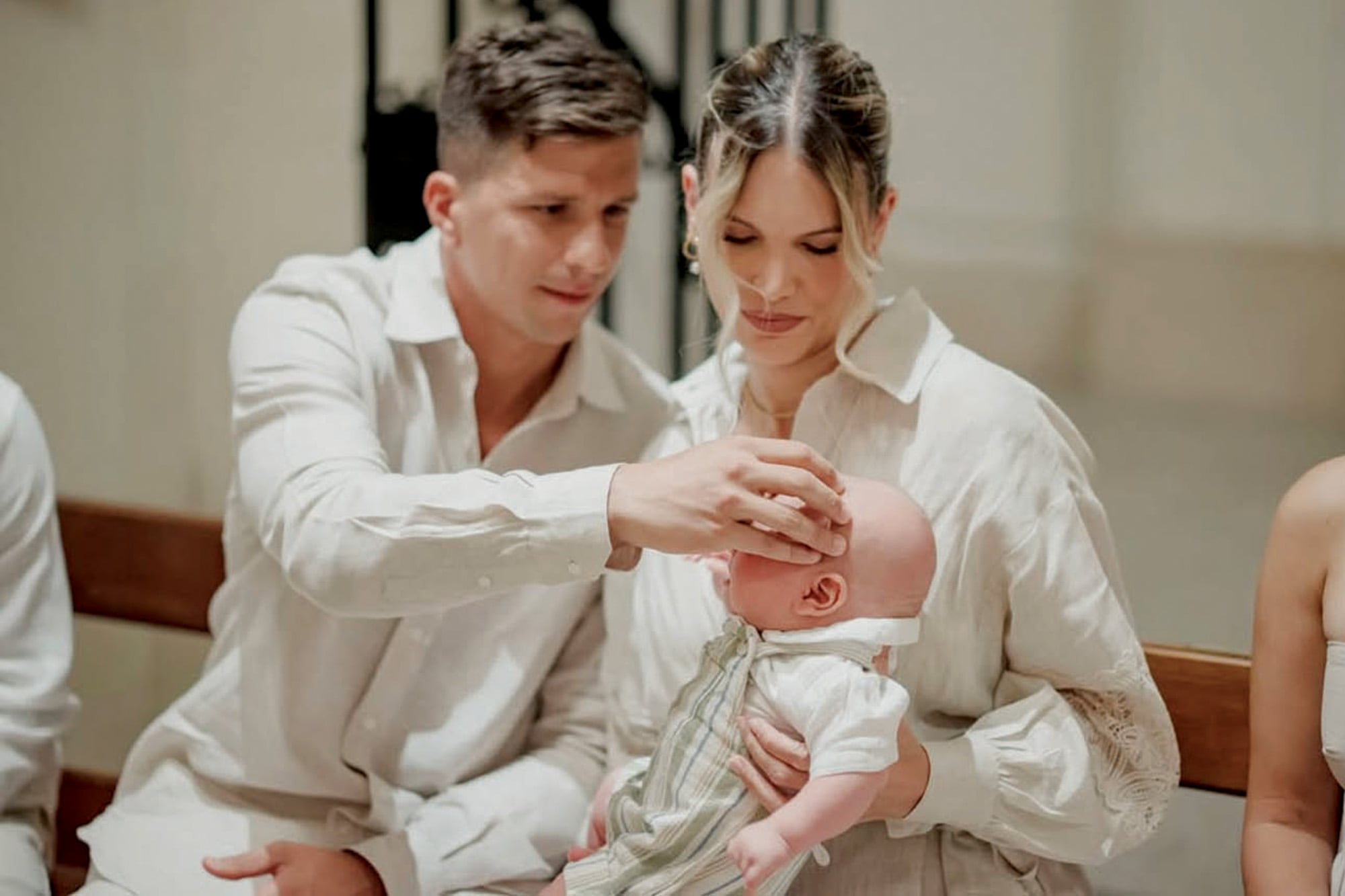 Gianluca le hace la unción a su hijo con el óleo bautismal