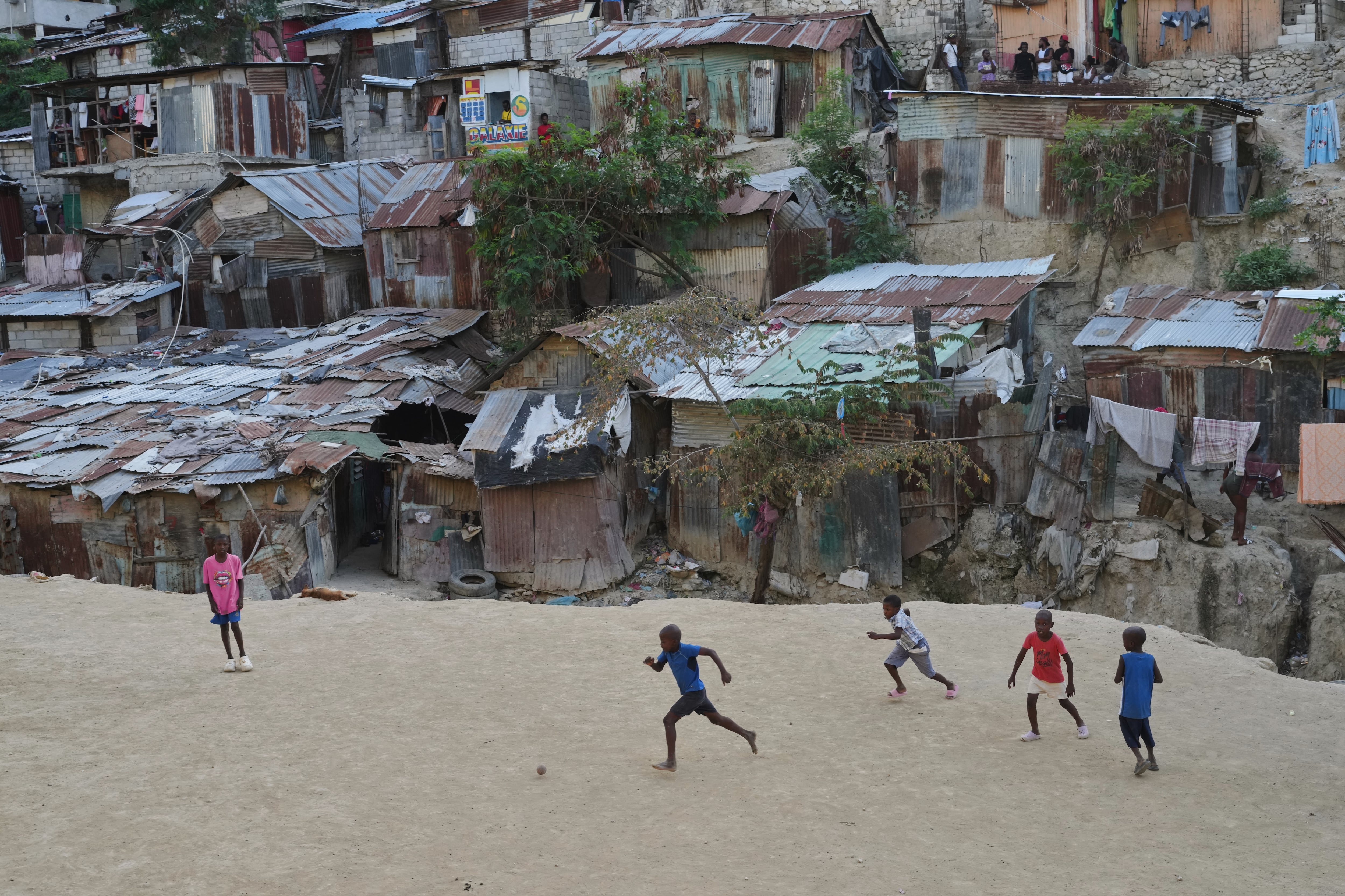 Un grupo de niños jugando al fútbol con una pelota de plástico en el barrio de Pétion-Ville, en Puerto Príncipe: el futuro de ellos es respetado por los ciudadanos, aun cuando juegan en las calles.