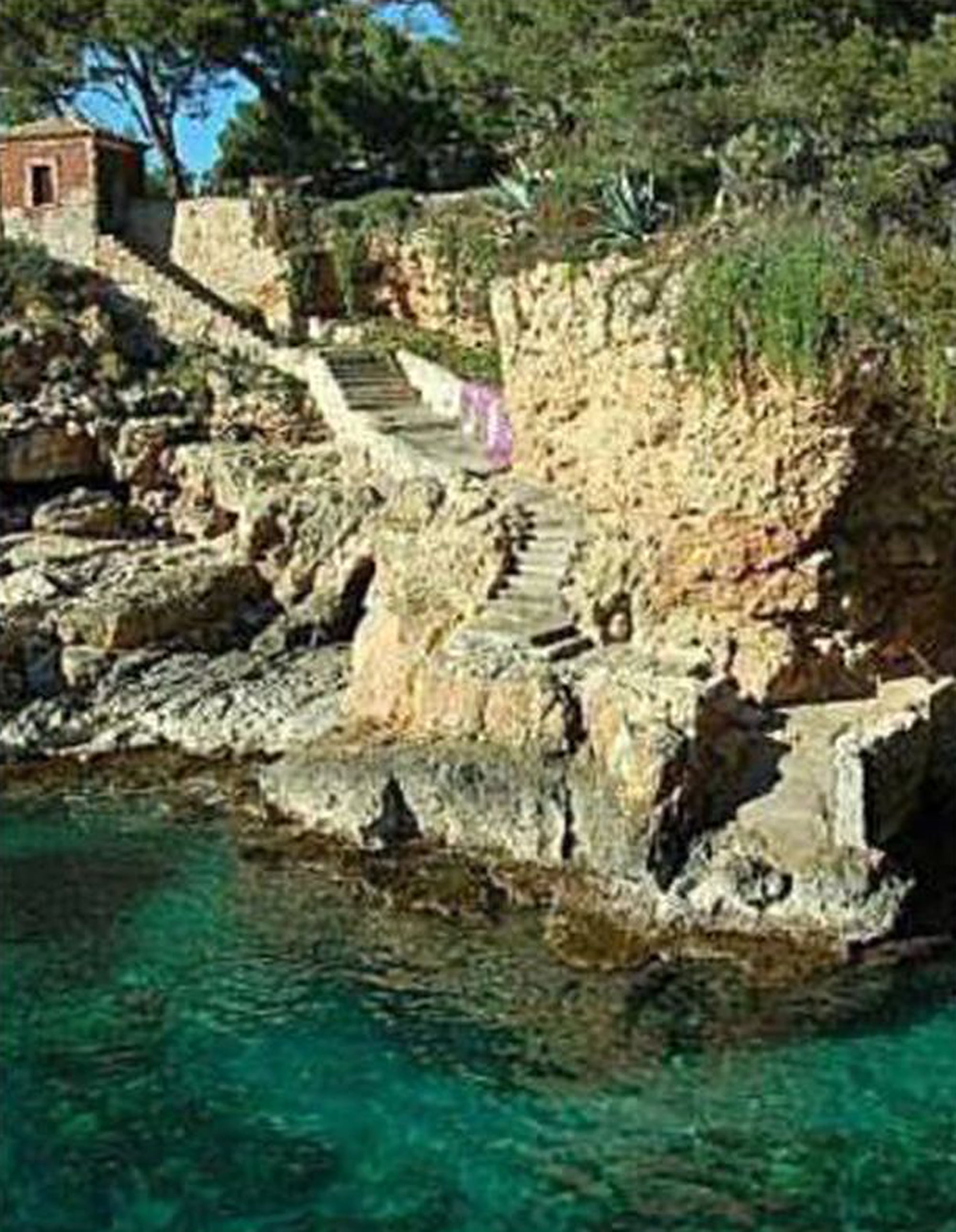 El chalet antiguo tiene una gran escalera con acceso al mar construida sobre las rocas
