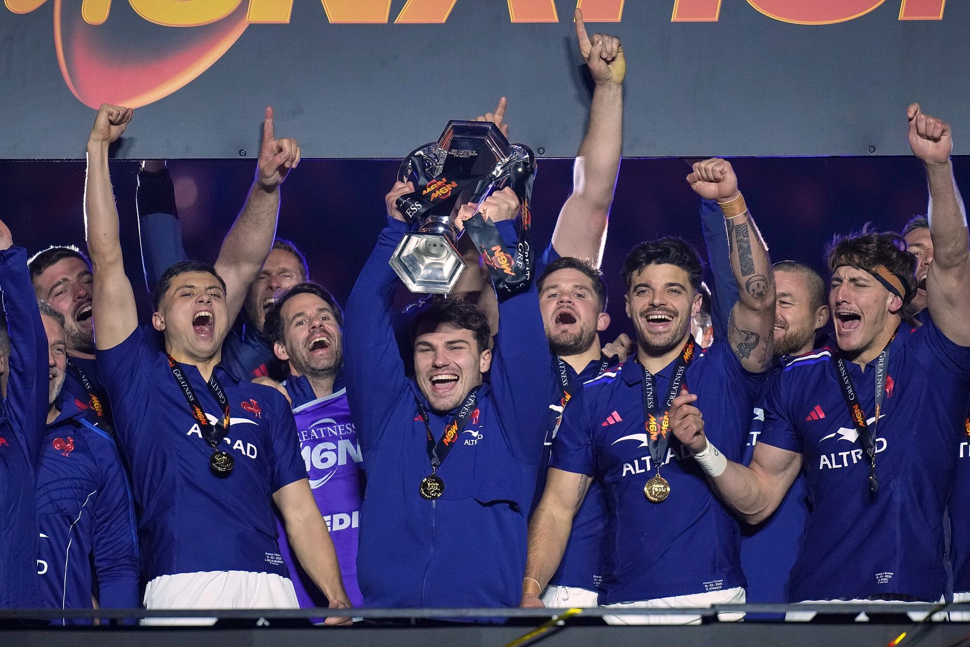 The French team players including Antoine Dupont, center, celebrate with the trophy after the Six Nations rugby union match between France and Scotland at the Stade de France in Saint-Denis, outside Paris, Saturday, March 15, 2025. (AP Photo/Christophe Ena)