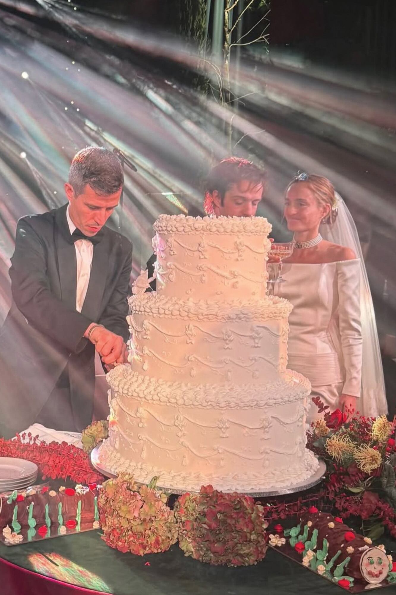 Los recién casados cortan la torta de tres pisos