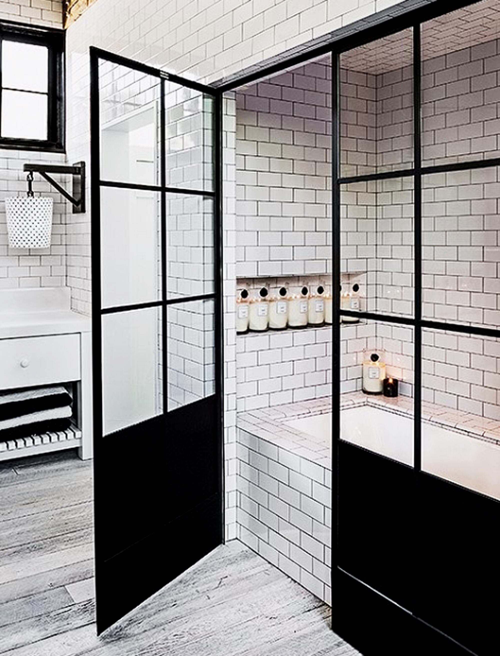 Los elementos negros del baño contrastan con los muebles lacados en blanco