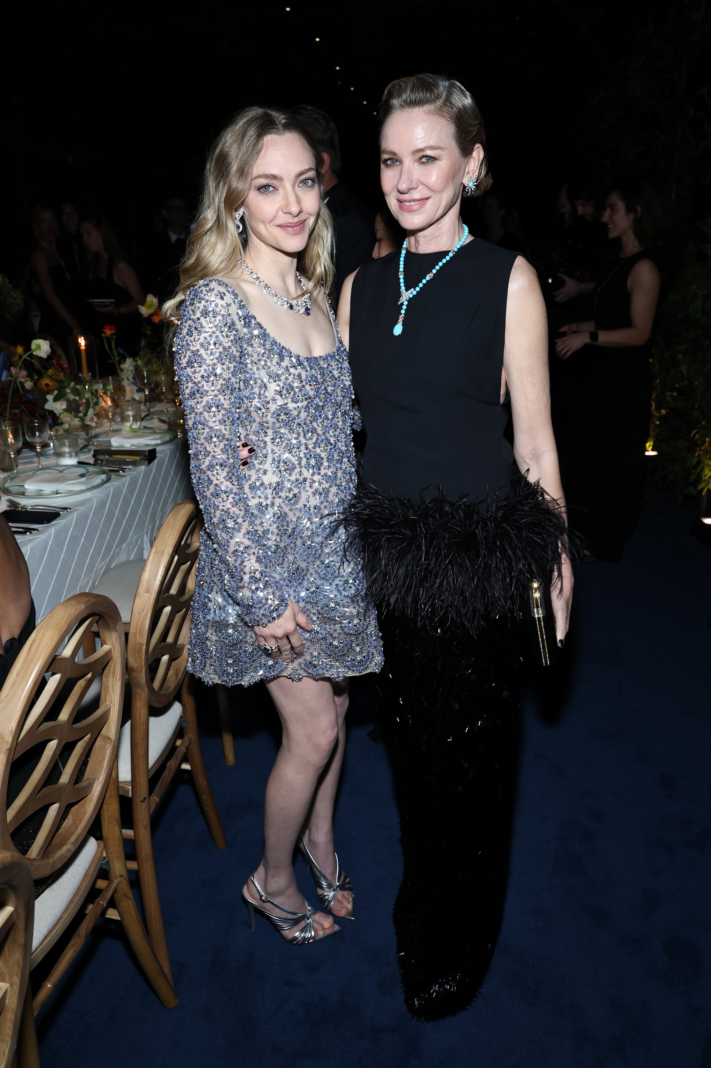 Amanda Seyfried, con un mini vestido de Oscar de la Renta de escote cuadrado, y Naomi Watts, lookeada con un modelo con falda de lentejuelas y cintura de plumas de Taller Marmo, compartieron mesa durante la gala