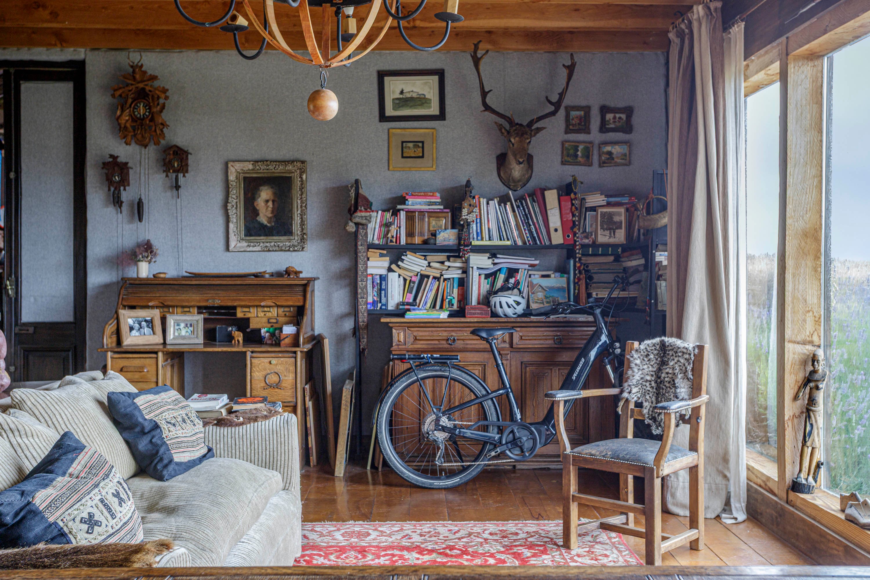 Alfombra persa, sofá con almohadones tejidos, pieles locales, muebles heredados y tantísimos libros.