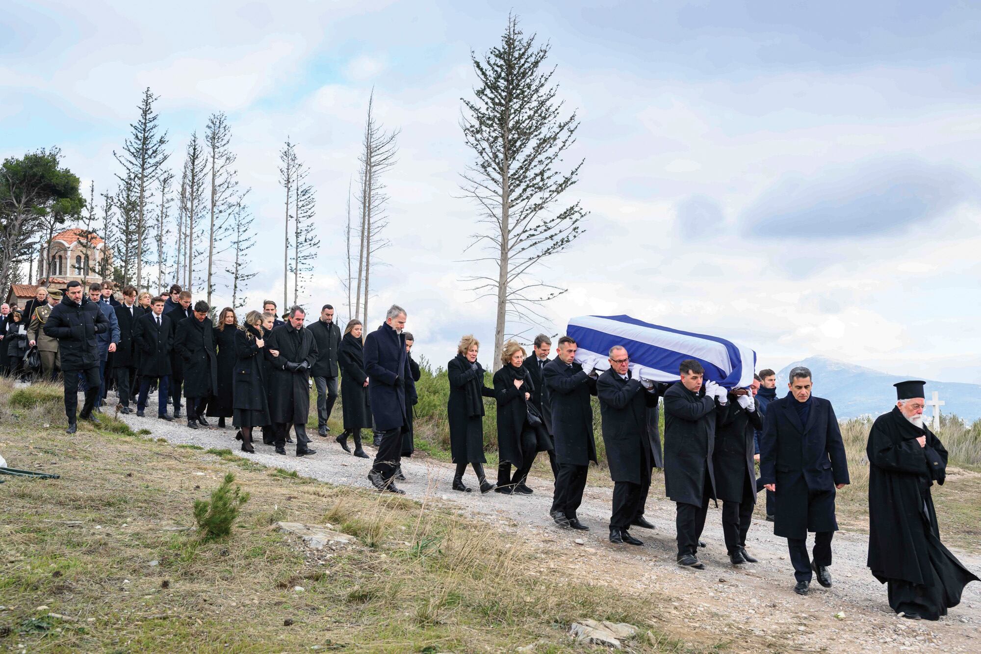 La familia real española y la familia real helena encabezan el cortejo fúnebre en el cementerio de Tatoi, el lunes 19. El féretro de la princesa Irene llega envuelto en la bandera griega