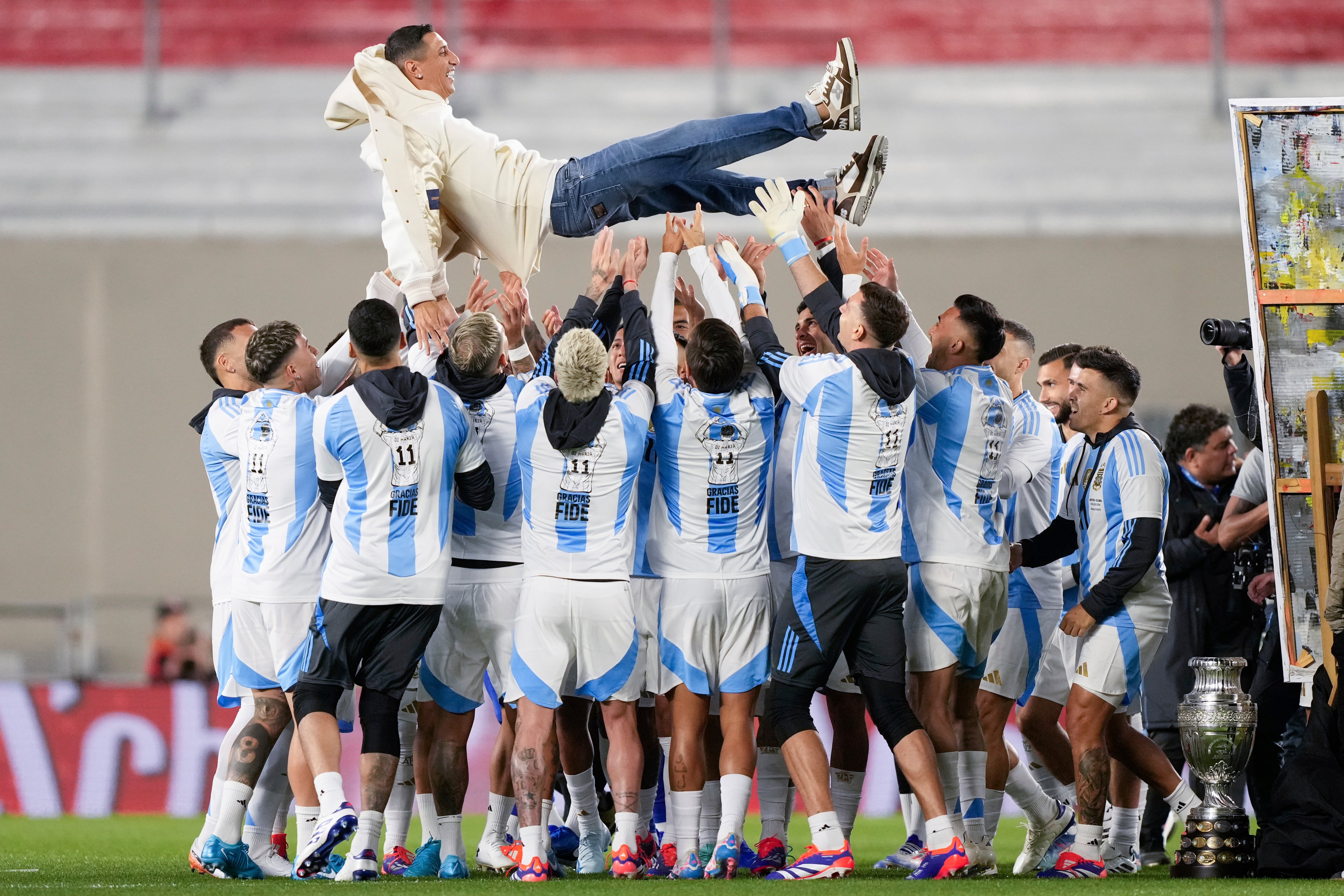 Los futbolistas de la Argentina levantan a Di María en el homenaje por su retiro del seleccionado en la previa de un partido contra Chile, en el Monumental