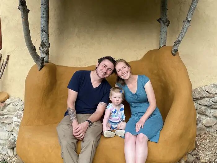 Daniel y Katherine junto a su hija en un sillón que hicieron con adobe
