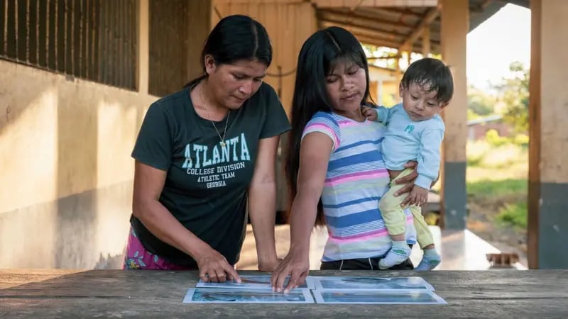 Miembros de la comunidad con fotos de los peces que descubrieron