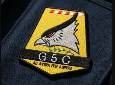 El escudo del Grupo 5 con el lema