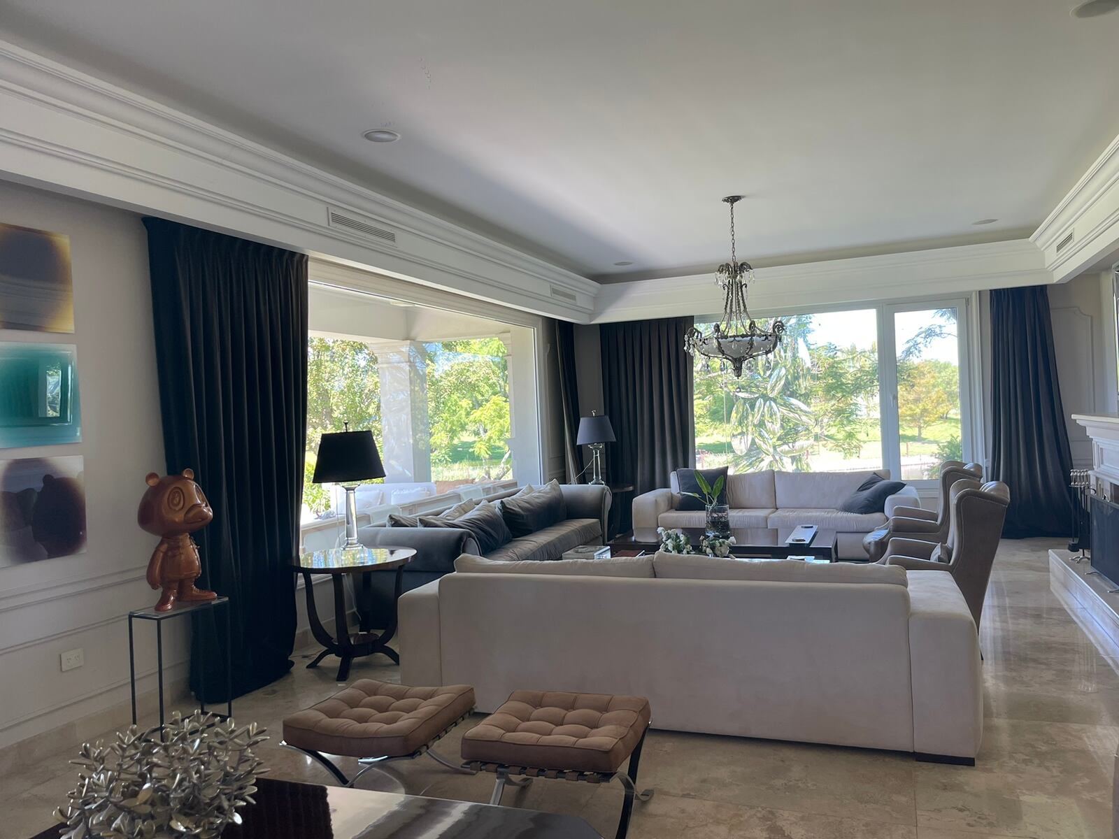 El living se destaca por sus amplios ventanales. A la izquierda de la imagen, la escultura de Rock bear, una de las obras más reconocidas de la artista Jowy Román