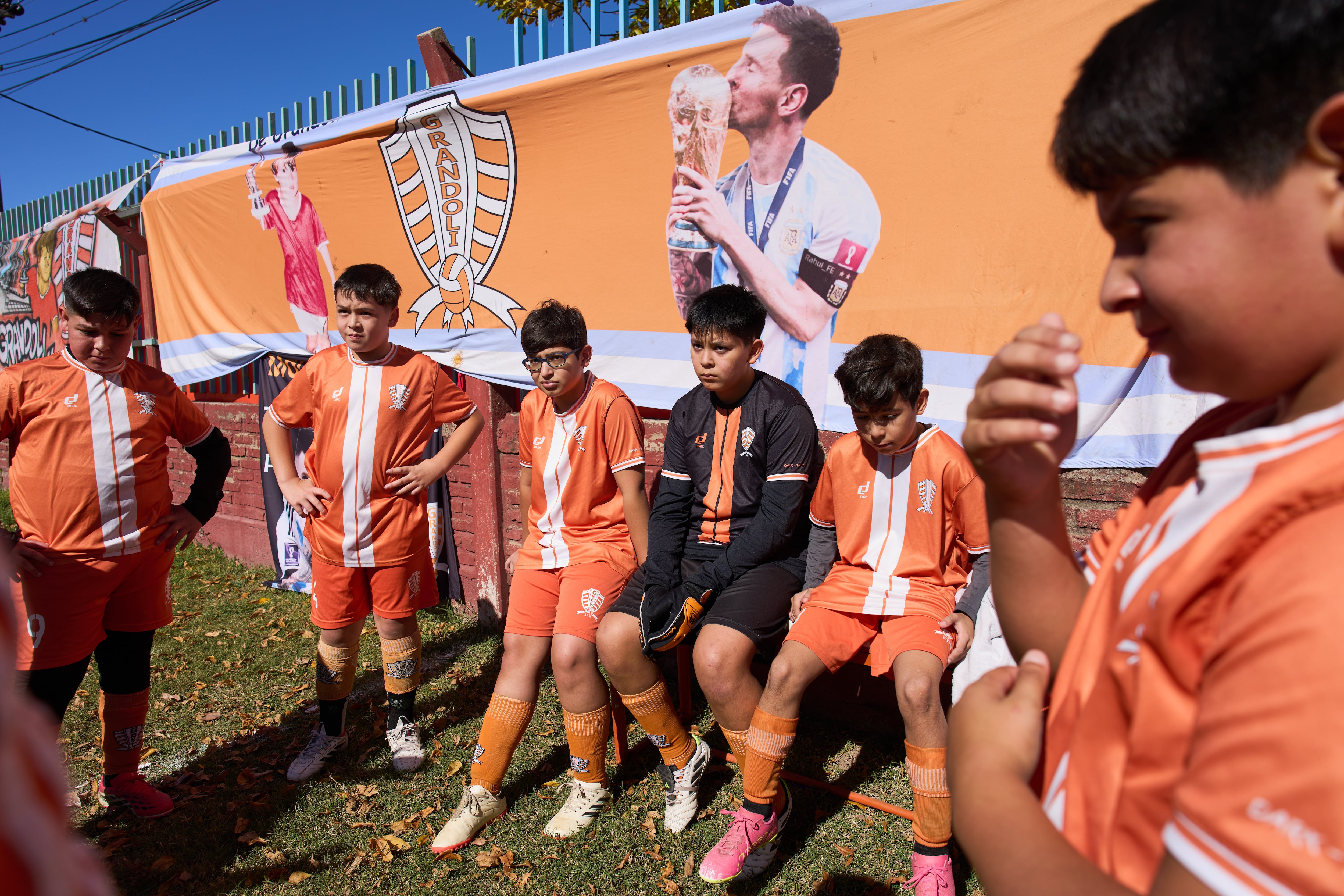 Niños del club de fútbol Grandoli, donde Messi jugó de niño, escuchan a su técnico previo a un partido en Rosario, Argentina, el sábado 2 de mayo de 2026. (AP Foto/Rodrigo Abd)